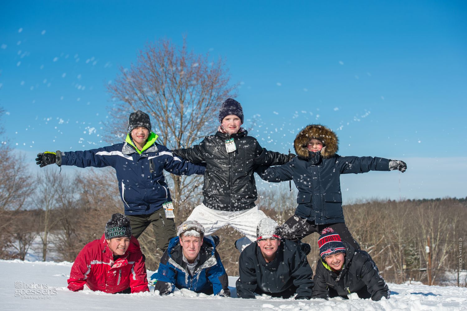 Boys making a pyramid in  a sunny snowy day