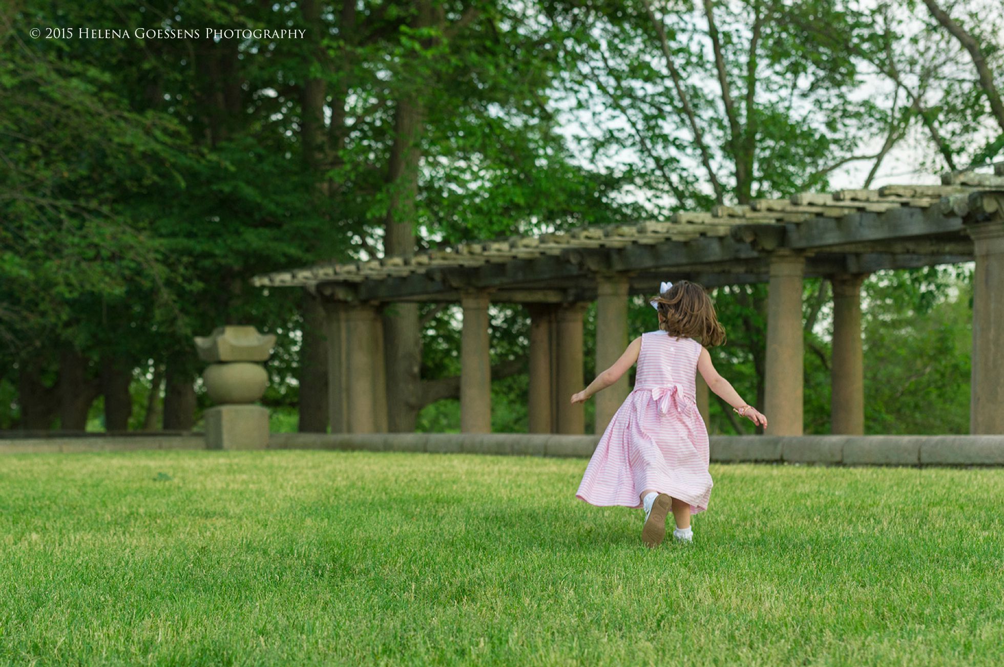girl with a pink dress running at the park