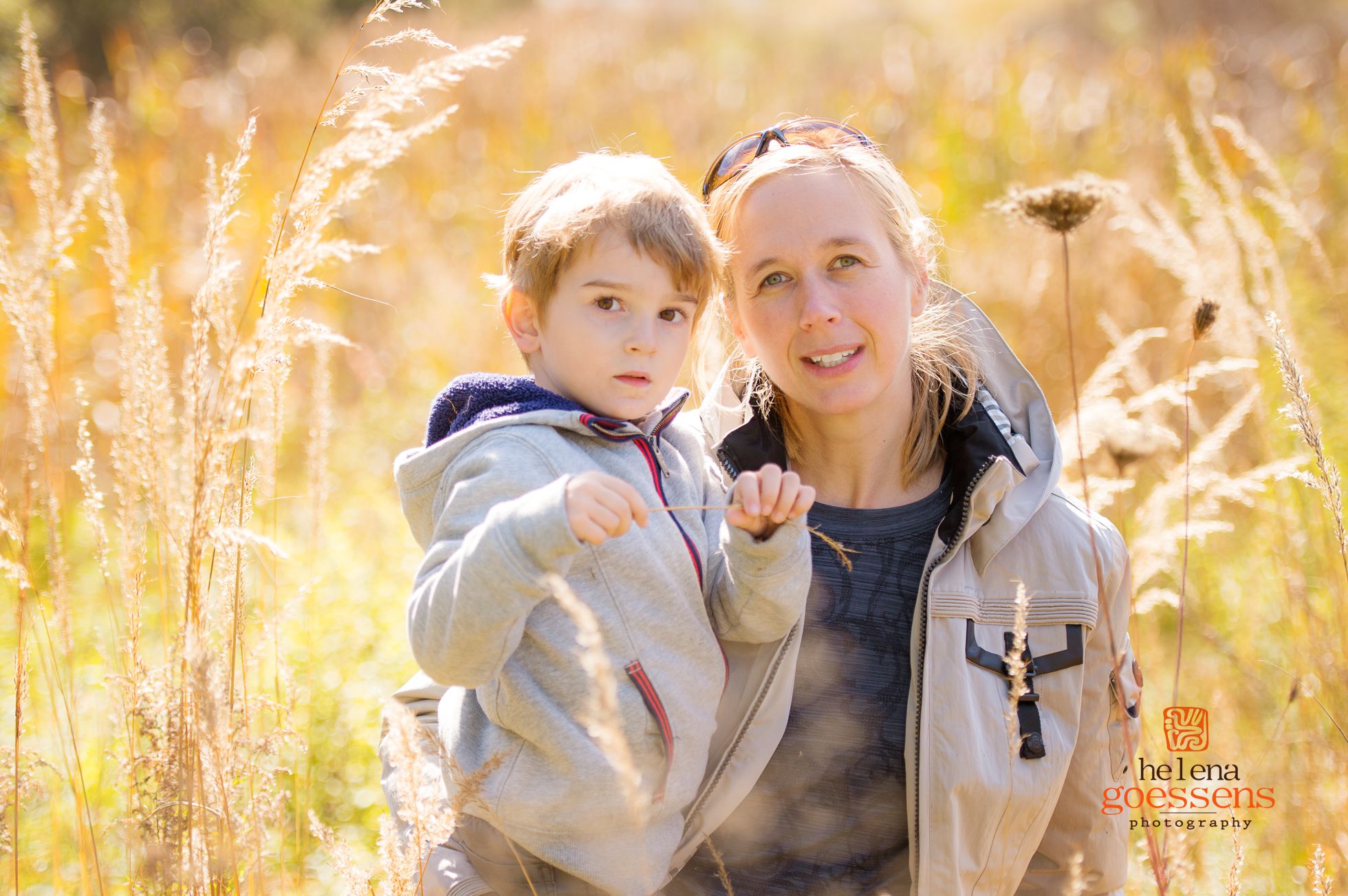 Blond mother and son in a tall grass field. Fall family portrait sessions