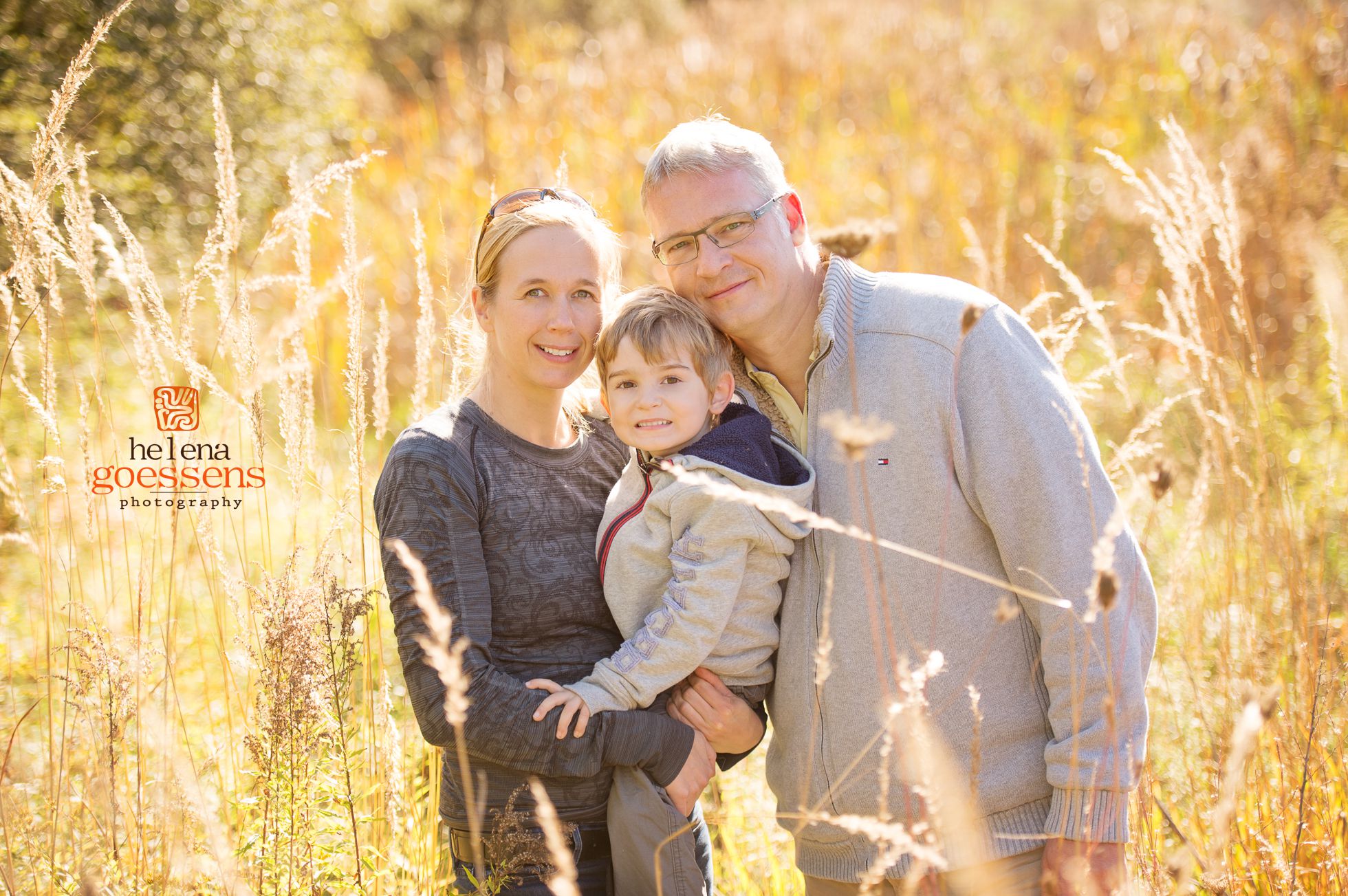 A family portrait session in a sunny tall grass field