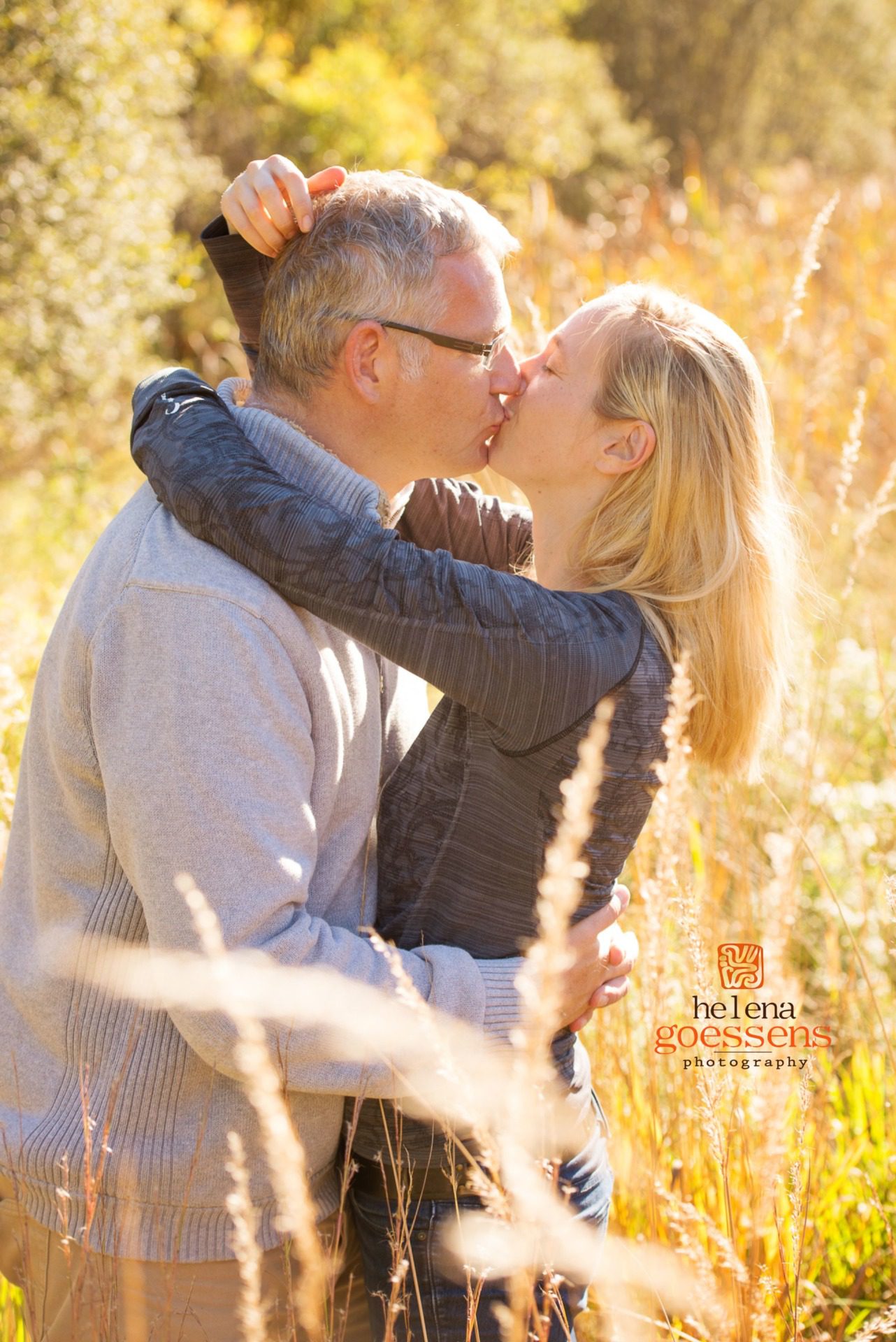 Couple kissing in a sunny tall grass field
