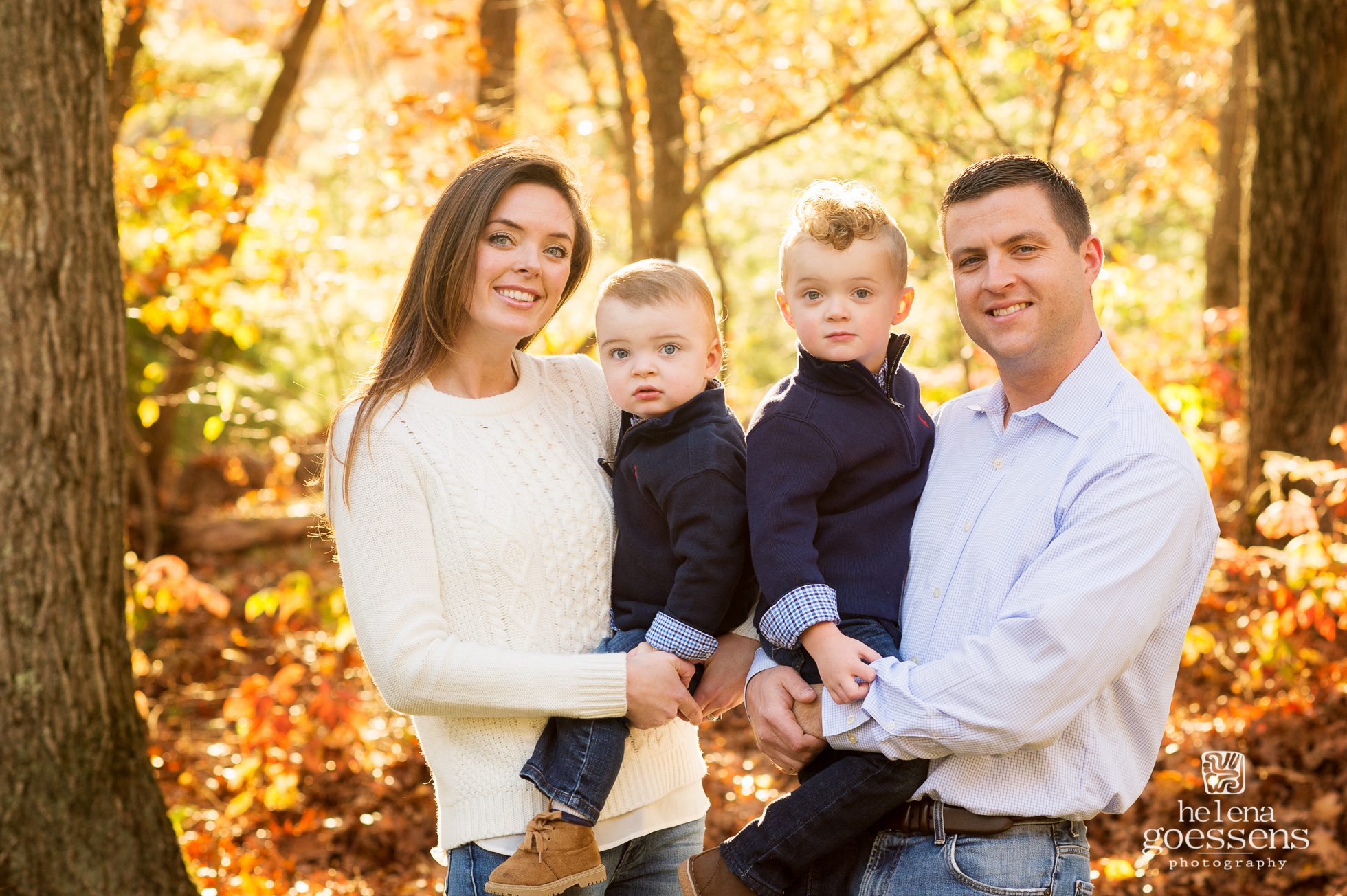 family of four with fall tree colors in the background