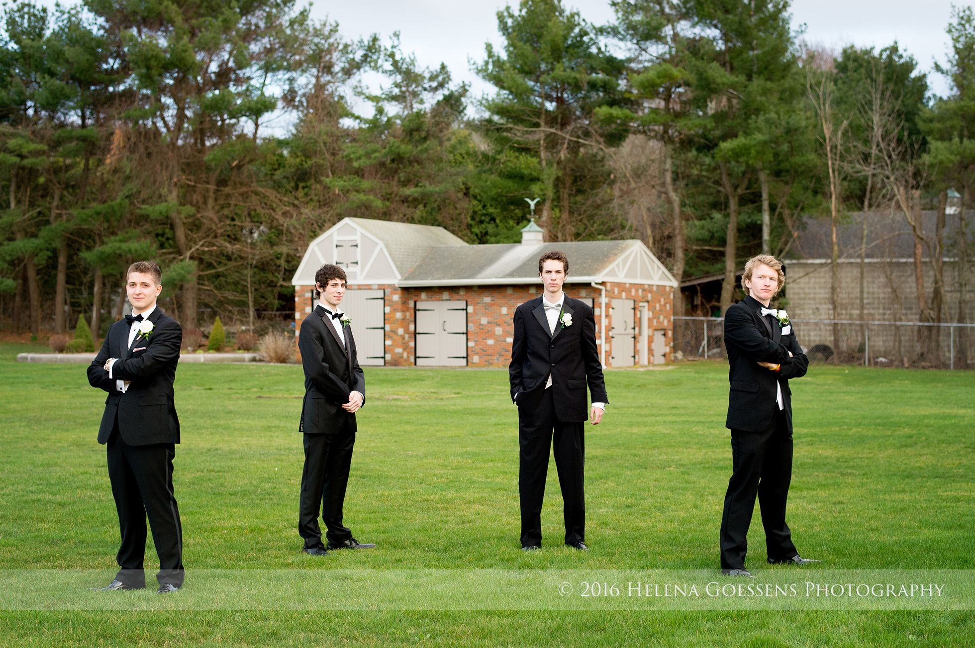 Four senior boys wearing black tuxedos