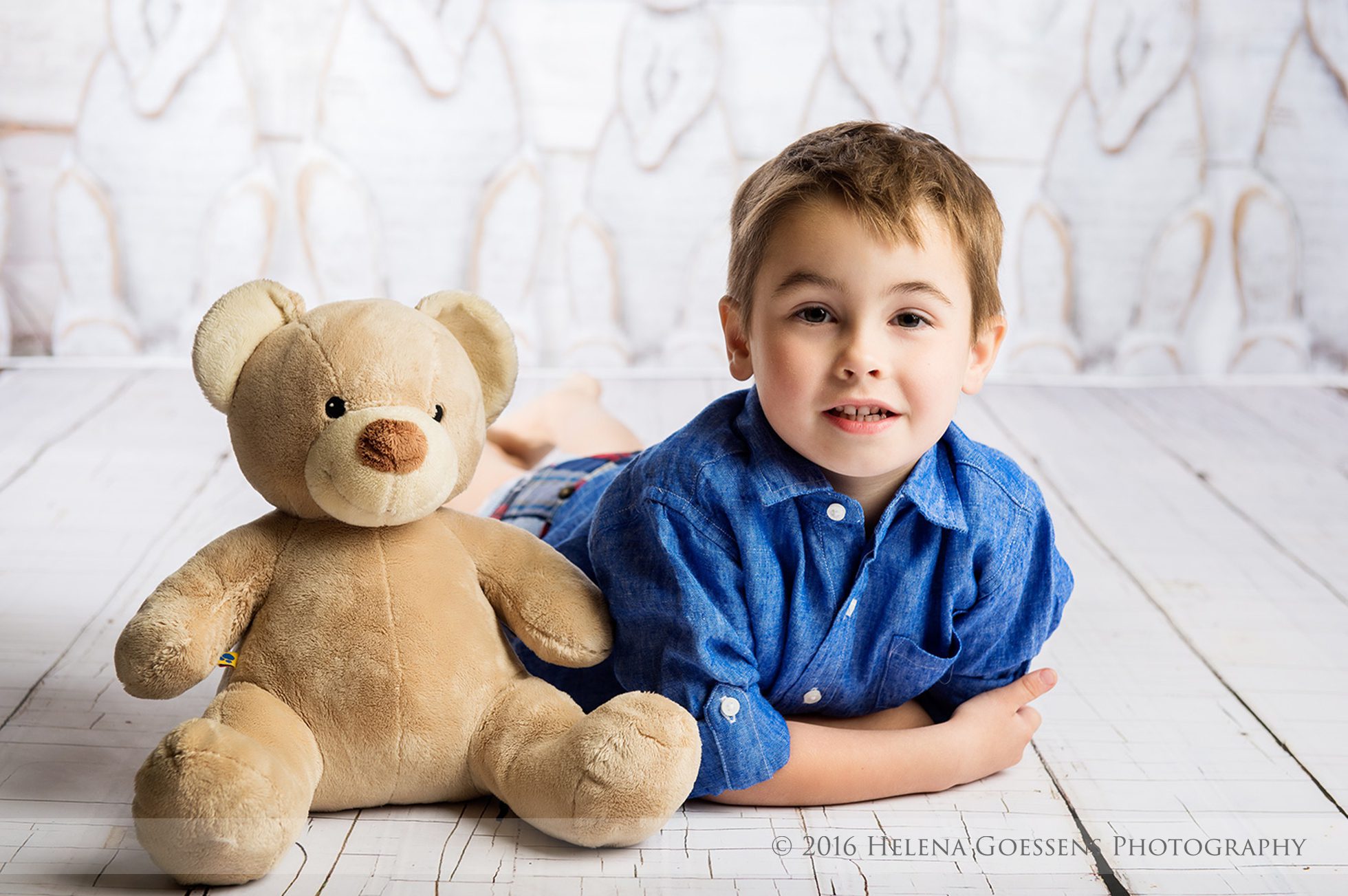 boy in a blue shirt and his cream teddy bear