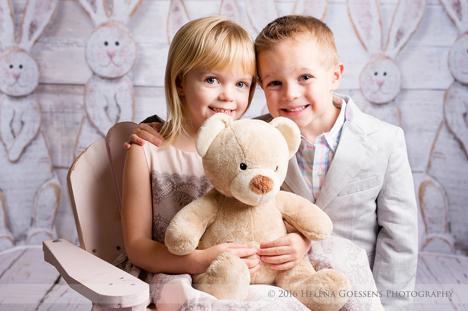 a blond boy and a blond girl holding a teddy bear