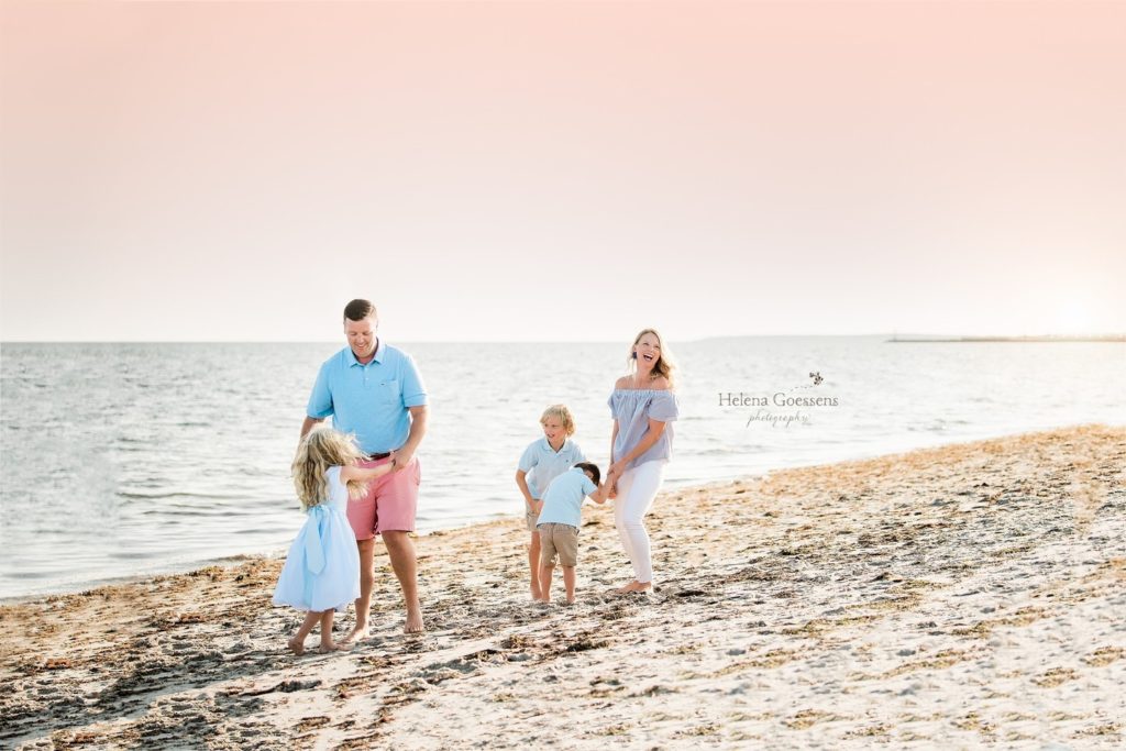 family of four walks on beach in Boston MA 