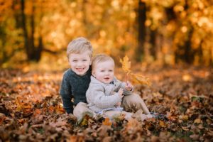 two little boys surrounded by leaves