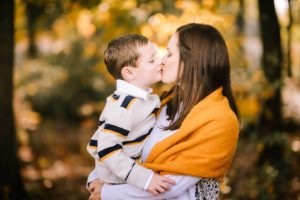 mom with son in yellow outfits, kissing. Fall portrait.