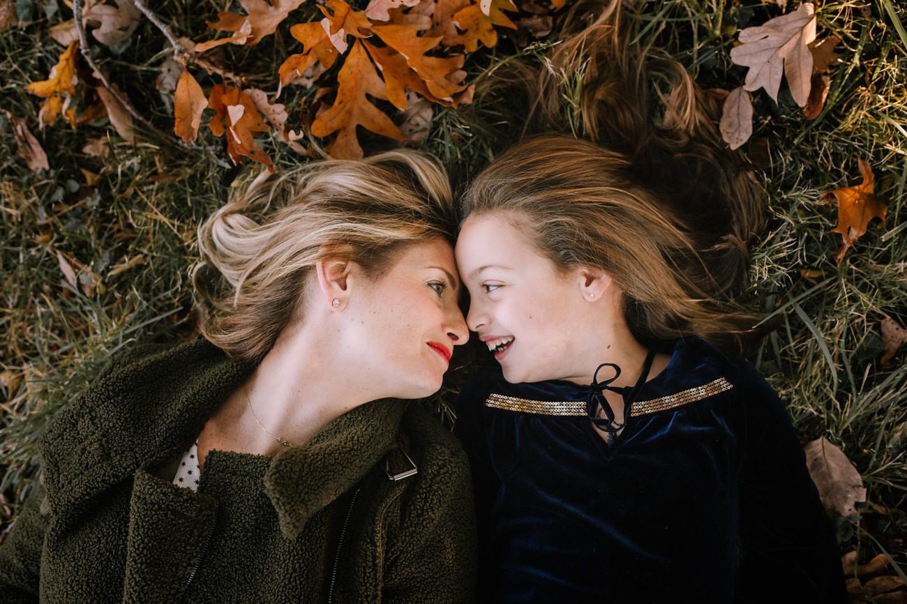mother and daughter on the floor with fall leaves
