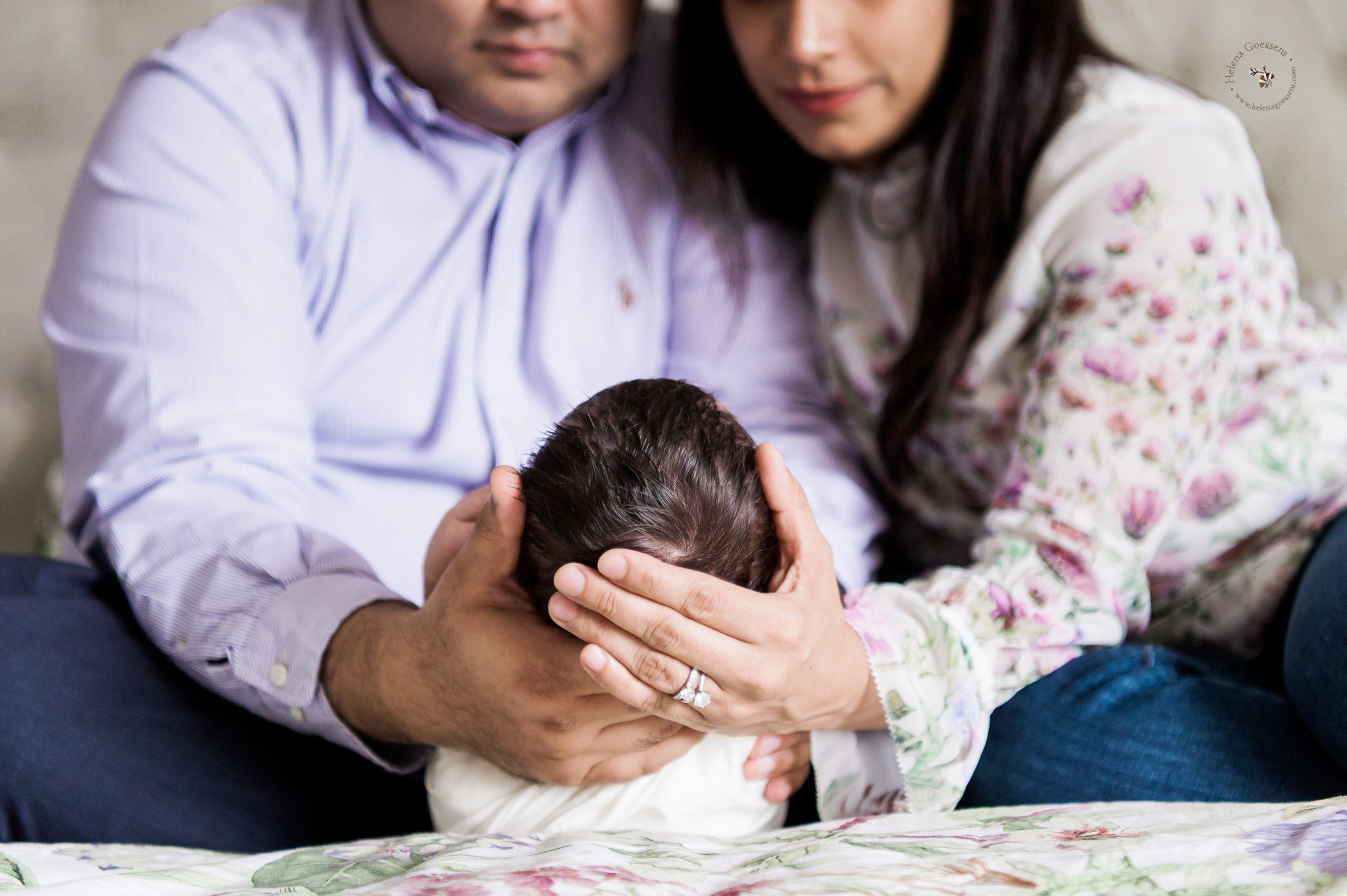 couple holding head of newborn
