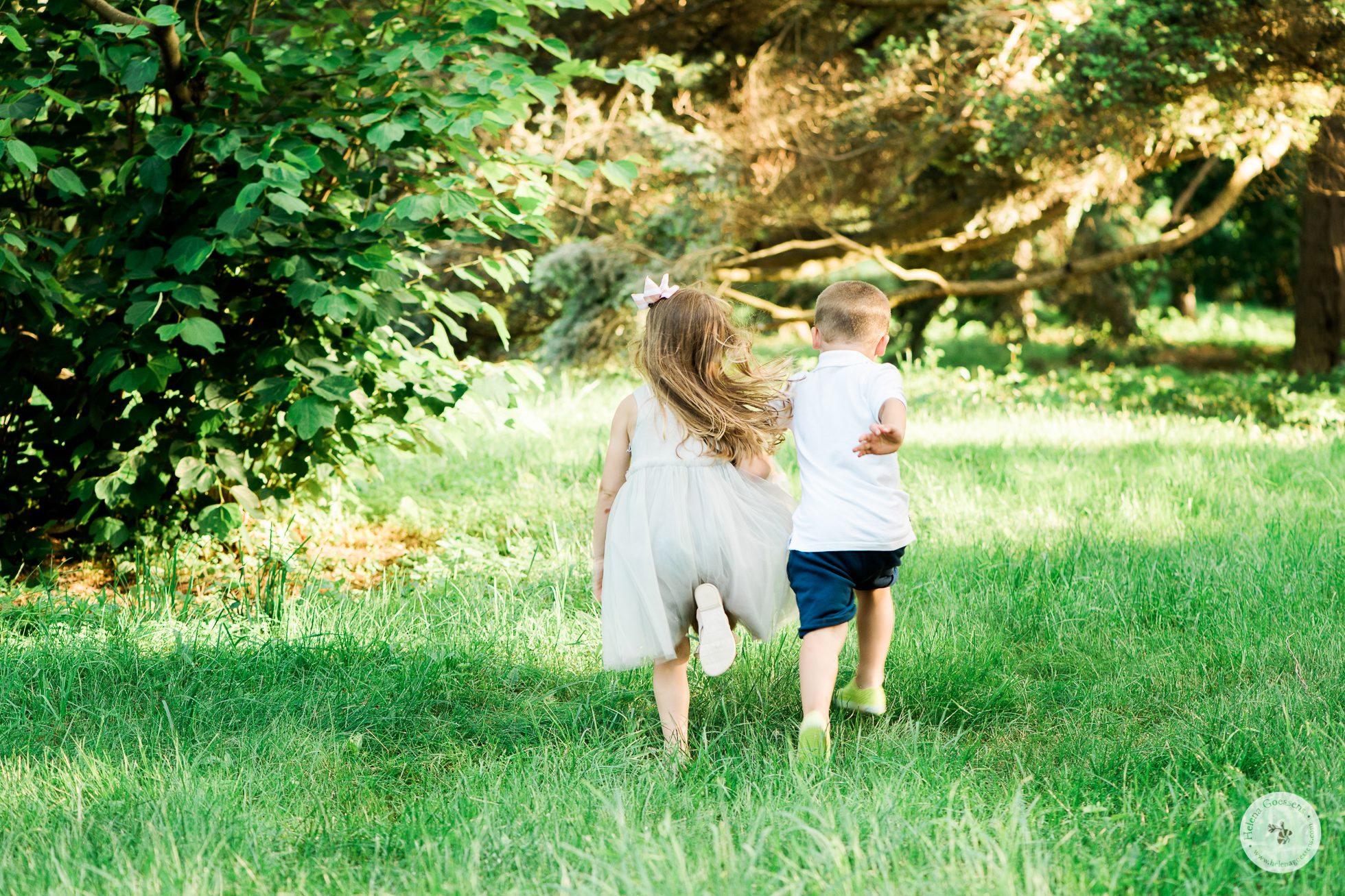 a girl and a boy running on a field.