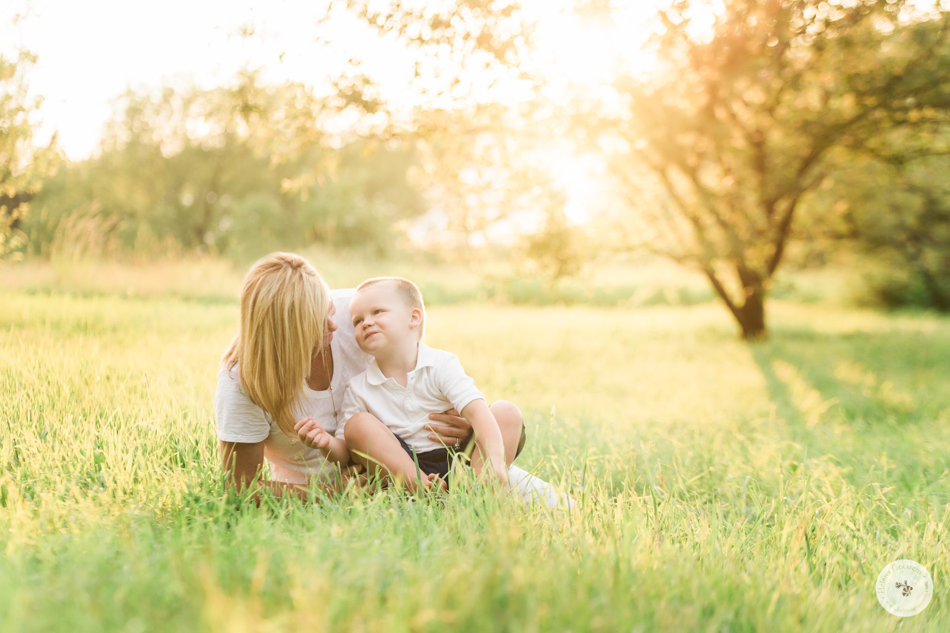 A mom with her little boy sitting on a golden field. Image by Helena Goessens Photography.
