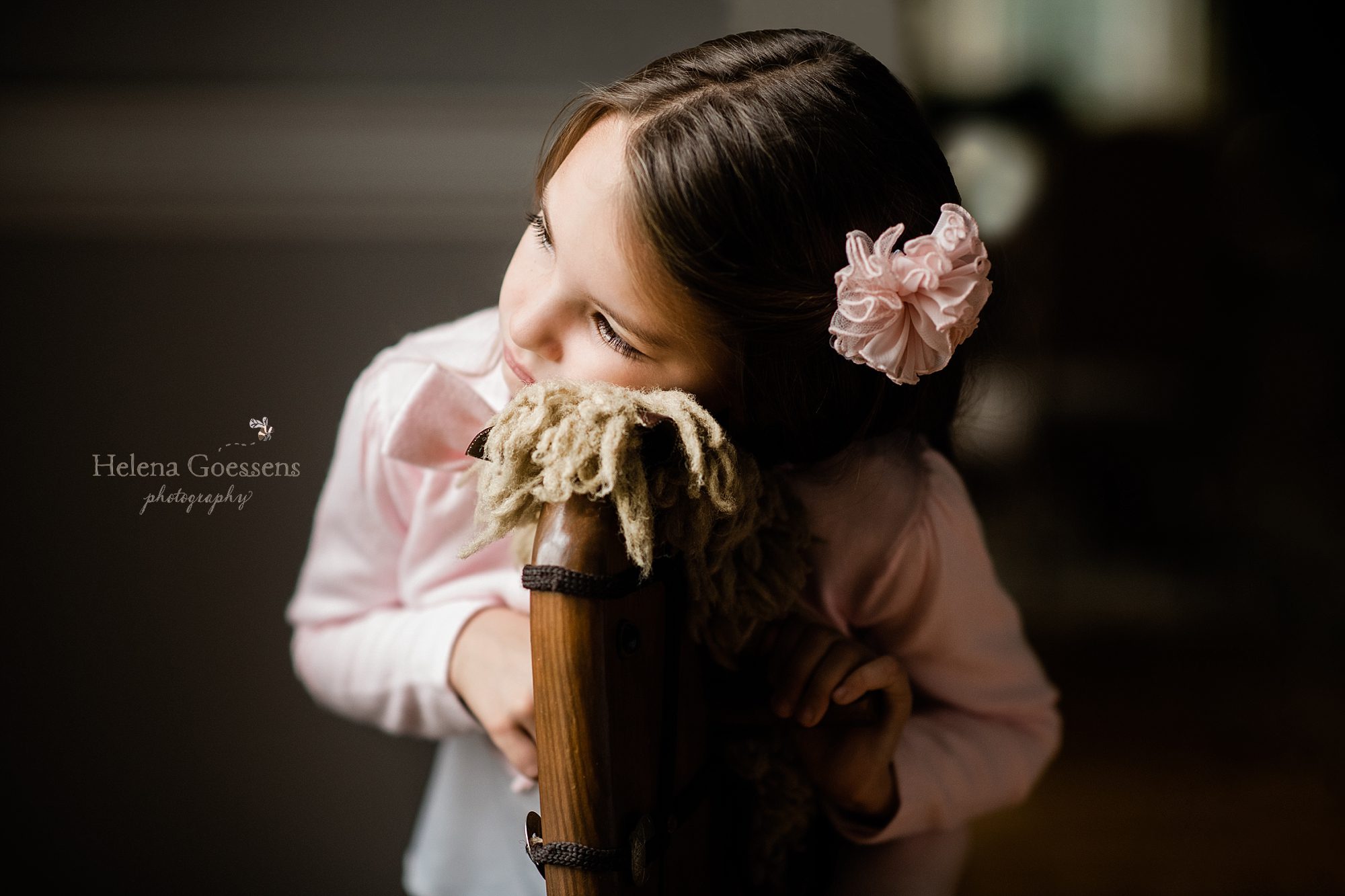 little girl rests on rocking horse photographed by Helena Goessens Photography