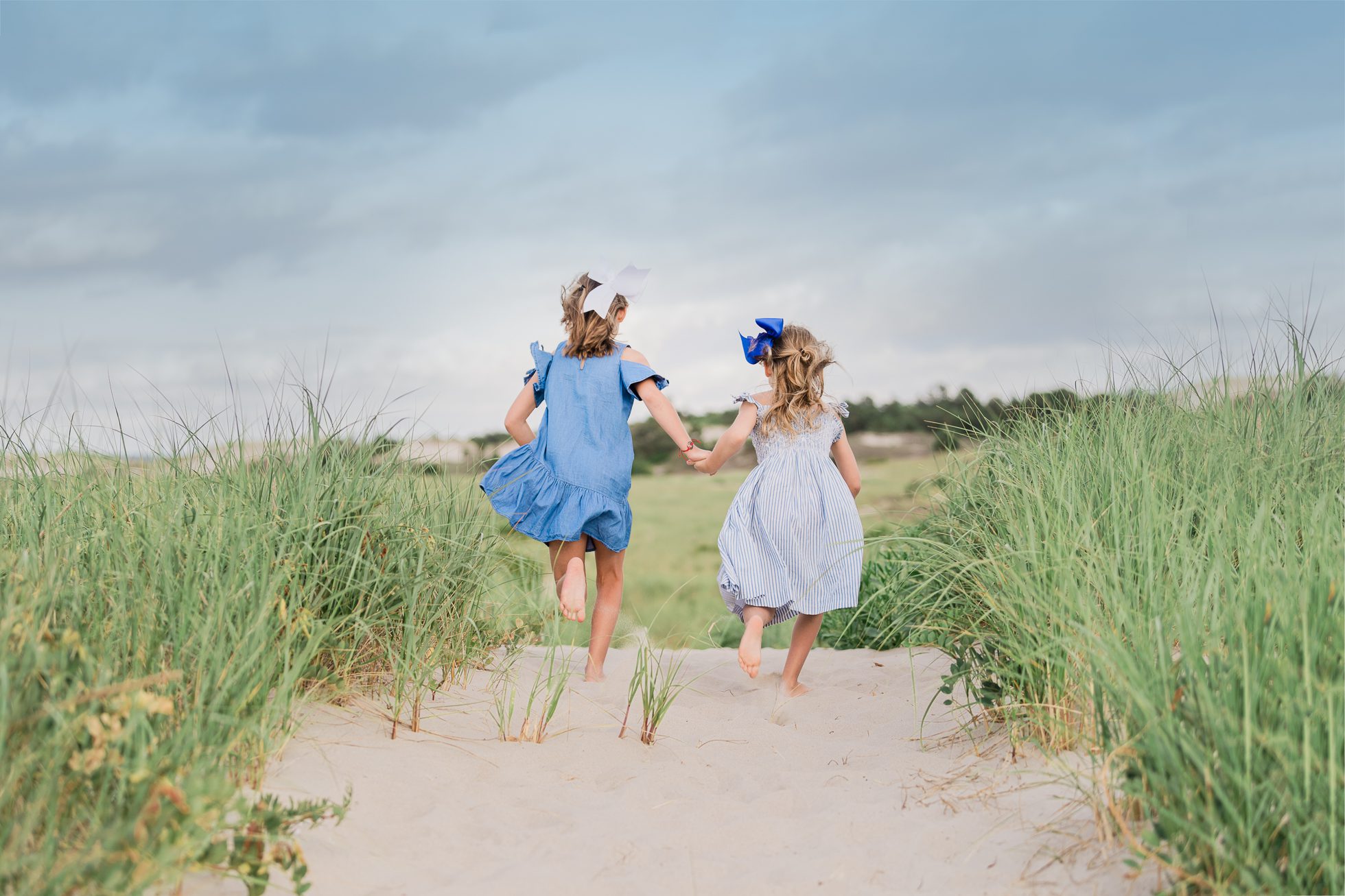 Two girls running in the dunes