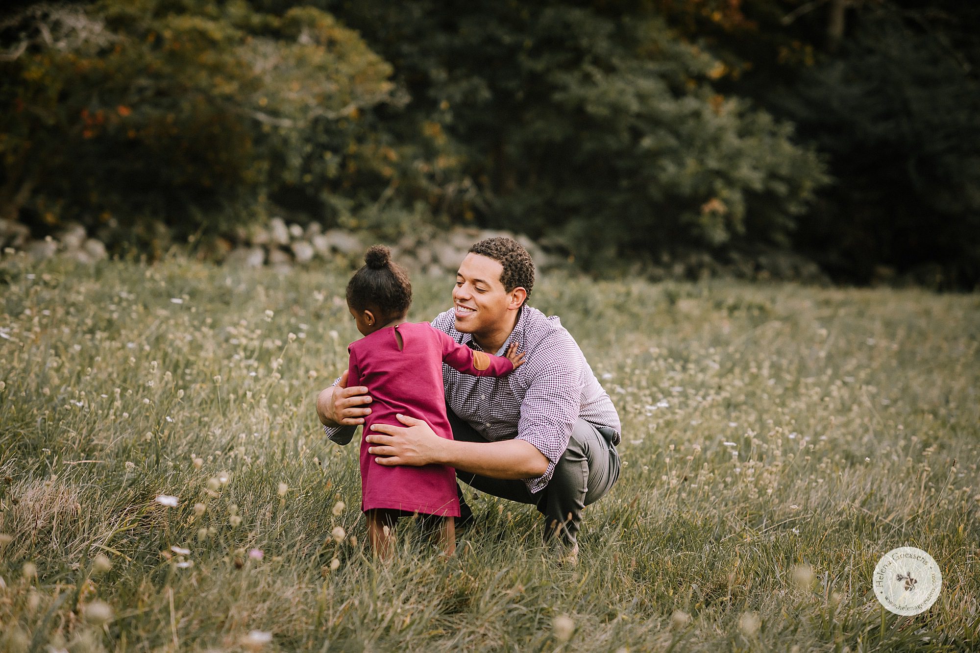 father and little girl play in field during family photos with Helena Goessens Photography
