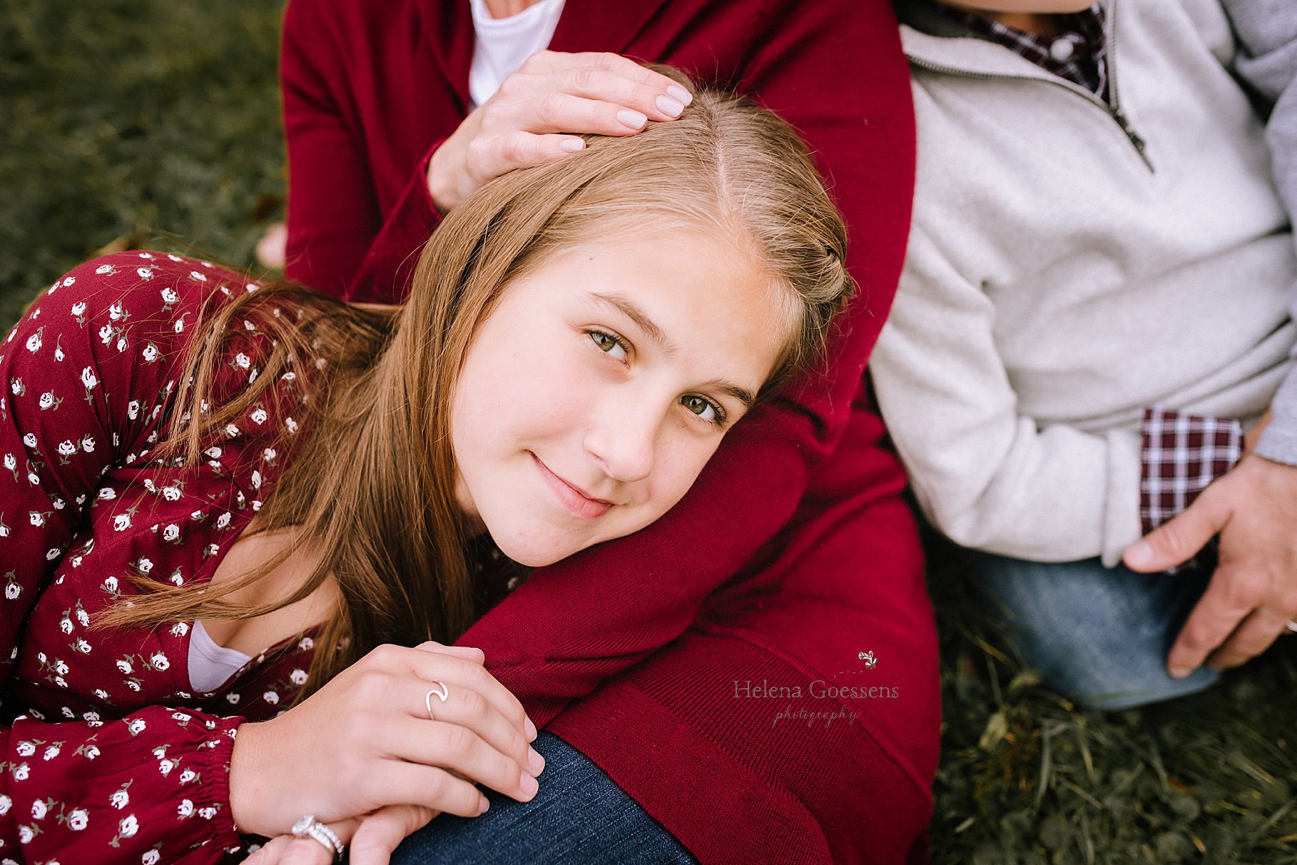 daughter lays with mom during family photos by Helena Goessens Photography