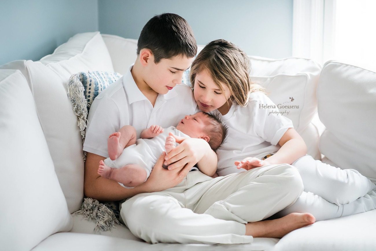 siblings look at baby with Helena Goessens Photography at Needham newborn session