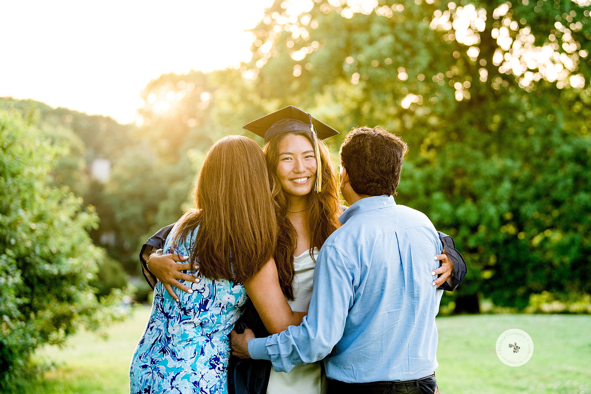 senior portrait of graduate hugging parents in Larz Anderson Park by Helena Goessens Photography