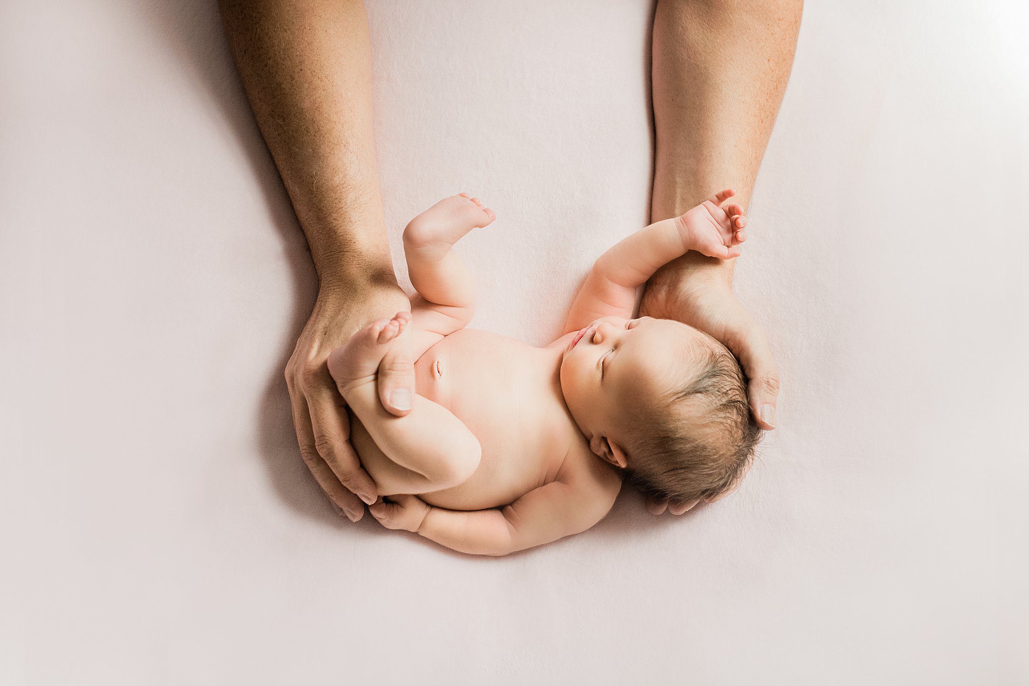newborn baby boy held by parents hands photographed by Helena Goessens Photography