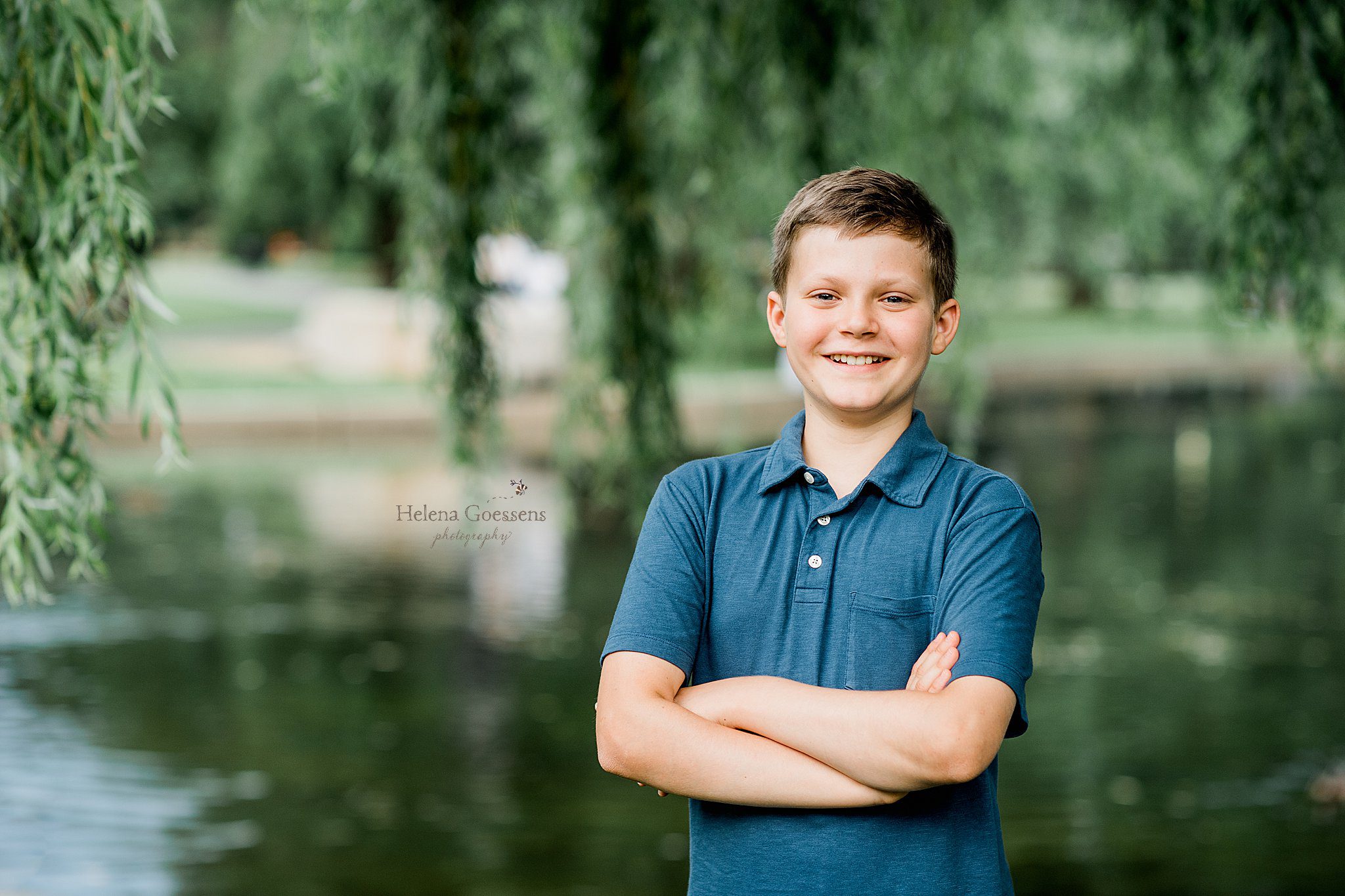 oldest son stands wearing blue polo in Boston Public Garden photographed by Helena Goessens Photography