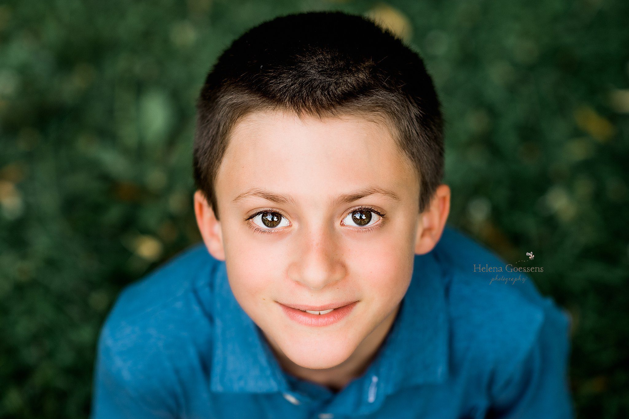 boy in blue shirt smiles at Helena Goessens Photography