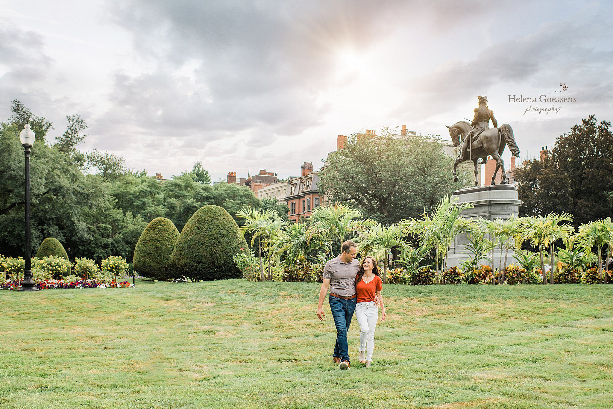 parents walk through Boston Public Garden by Paul Revere statue 