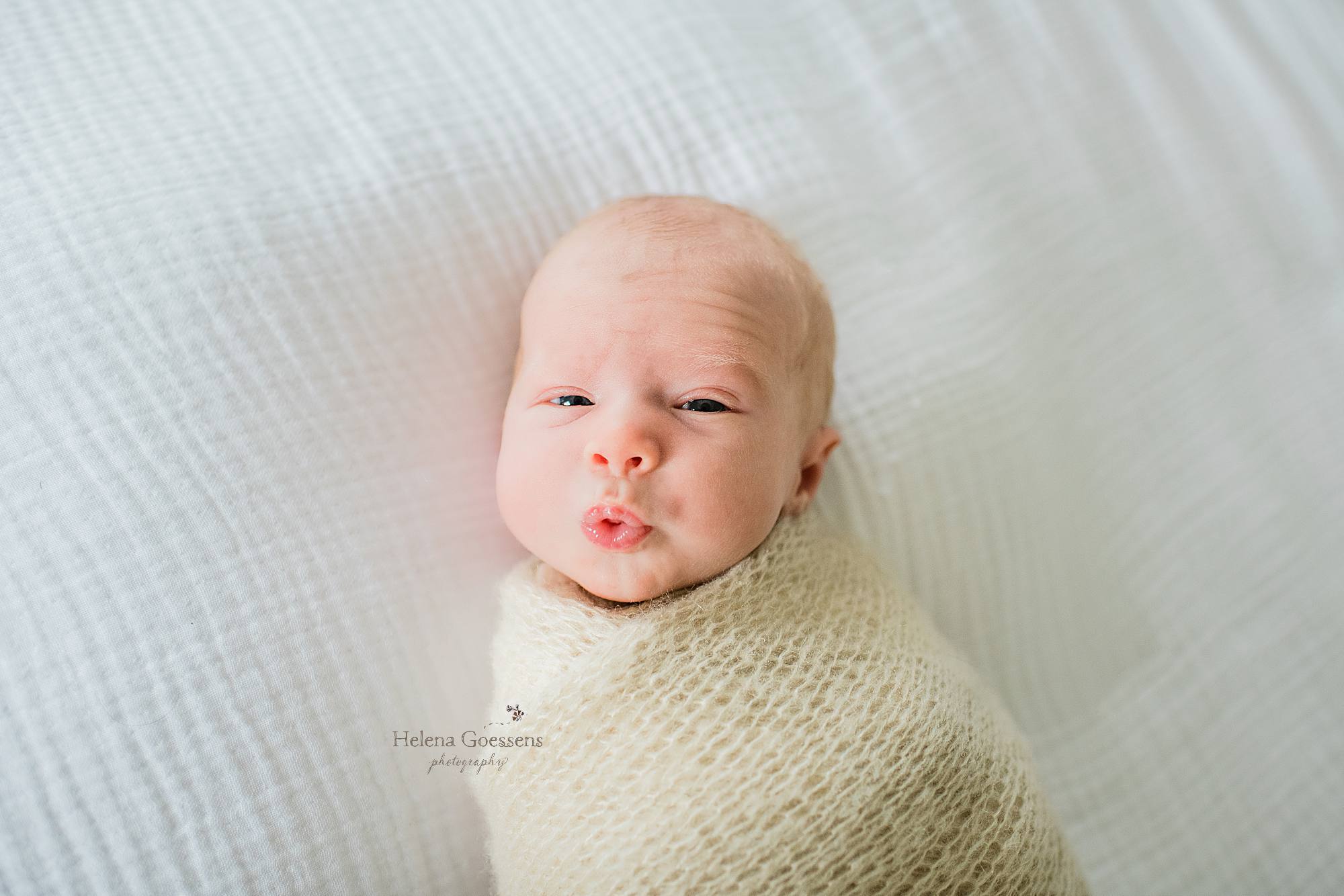 Helena Goessens Photography photographs newborn baby boy making faces during lifestyle session at home