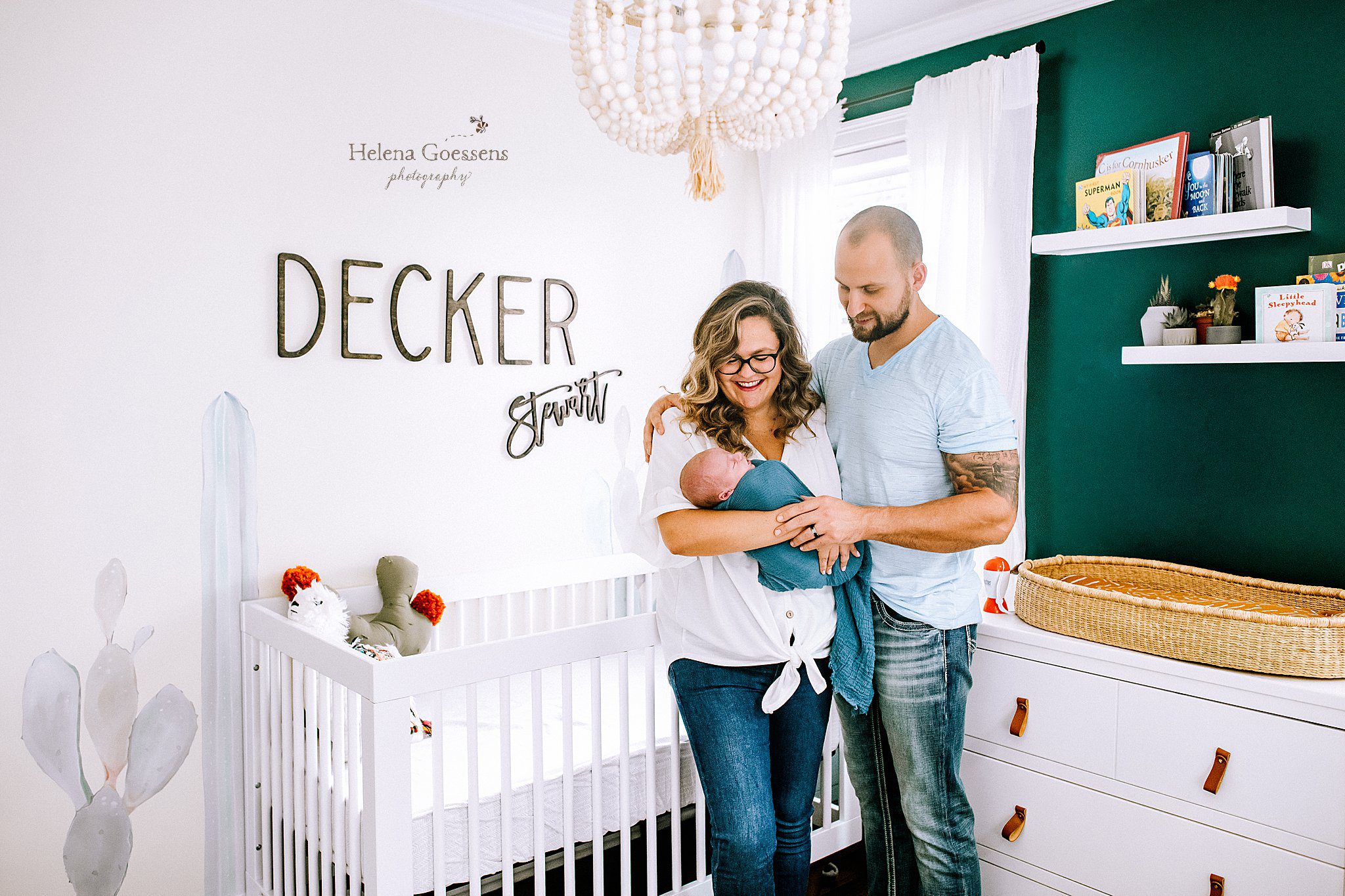 parents hold newborn baby in MA nursery photographed by Helena Goessens Photography