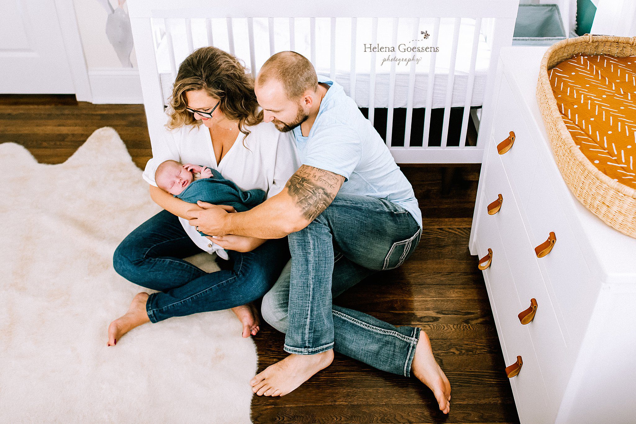 parents hold newborn baby by crib photographed by Helena Goessens Photography