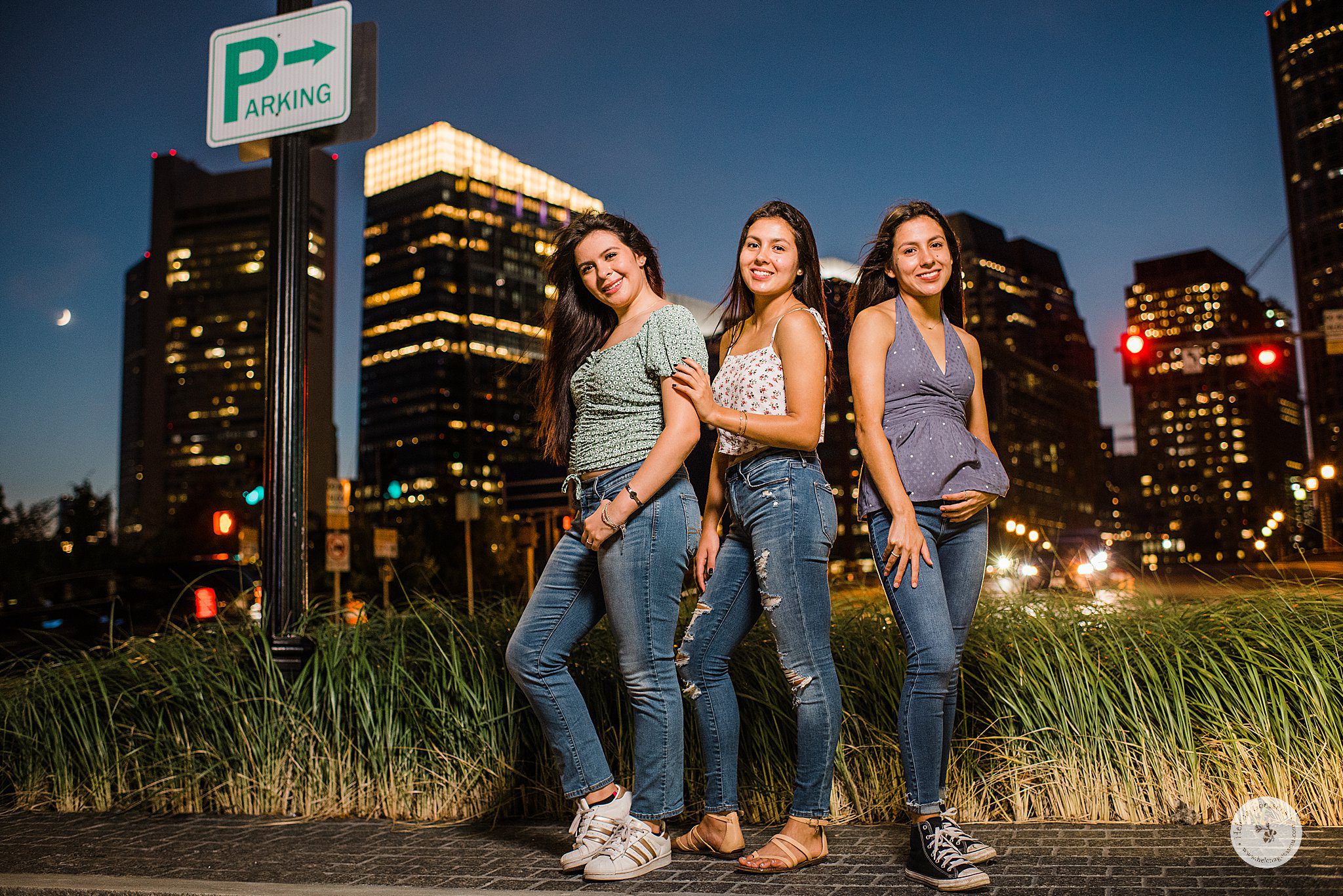 3 sisters pose by Parking sign in Fan Pier Park during MA family session with Helena Goessens Photography