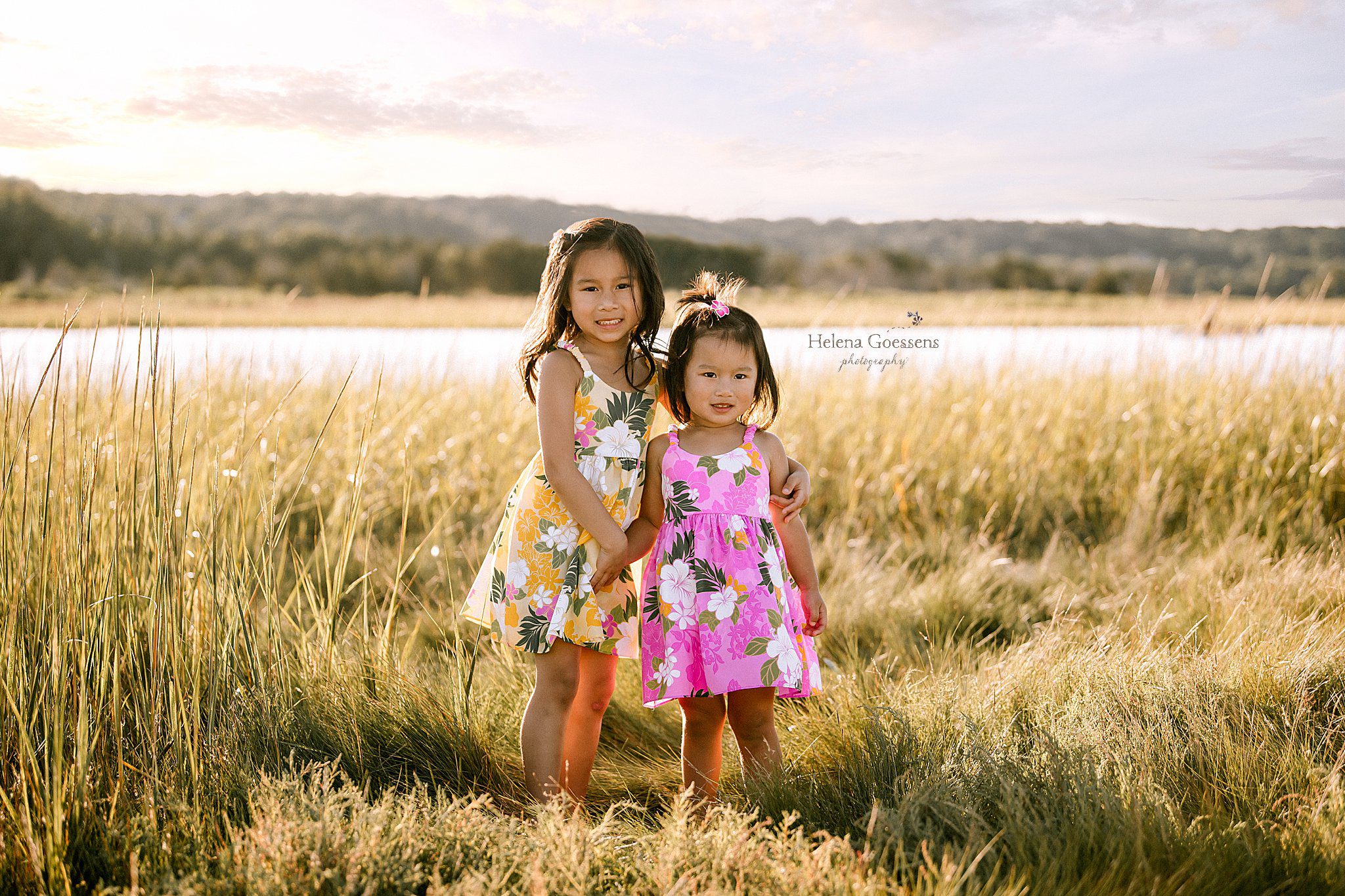 sisters in matching tropical dresses pose in marsh at Rexhame Beach 