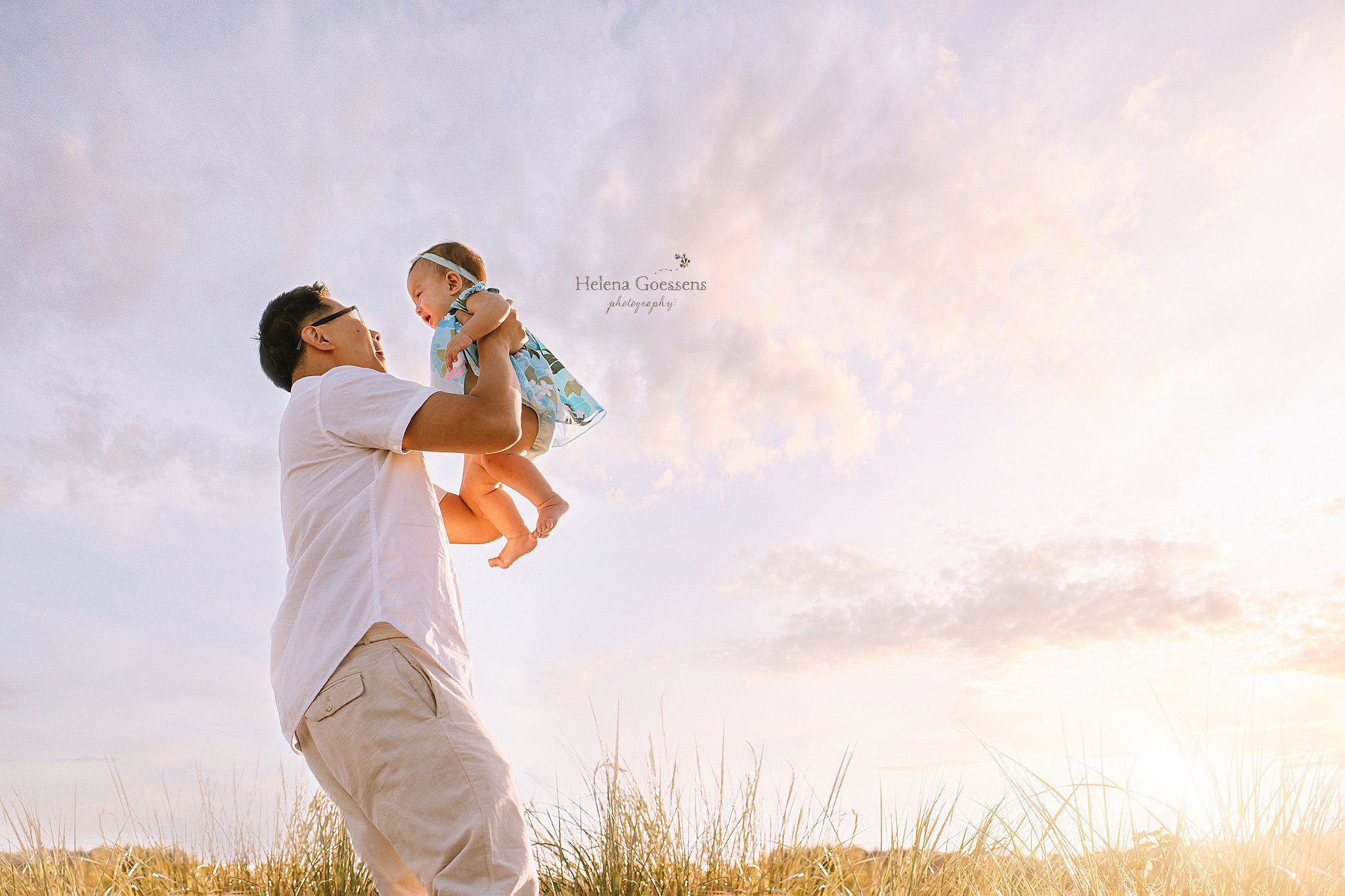 Helena Goessens Photography photographs dad lifting baby girl in blue dress