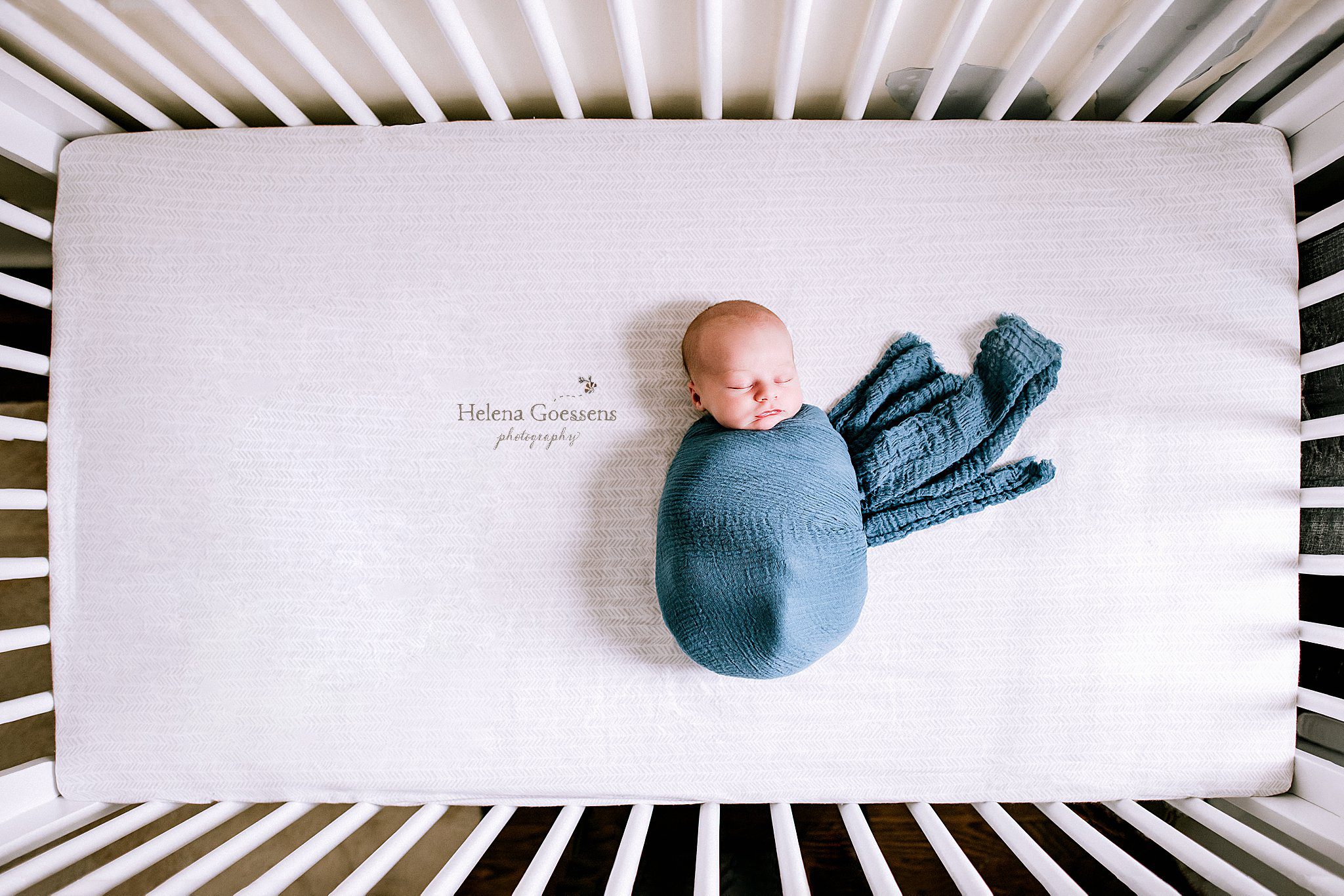 baby boy in blue wrap sleeps in crib photographed by MA newborn photographer Helena Goessens Photography