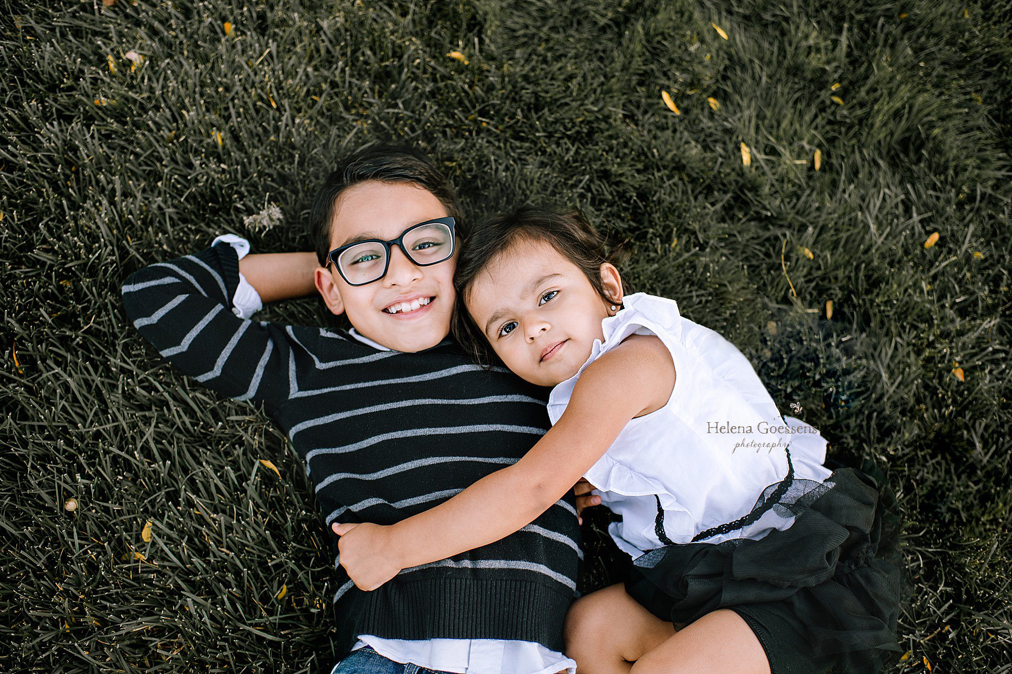 Helena Goessens Photography photographs siblings laying in grass