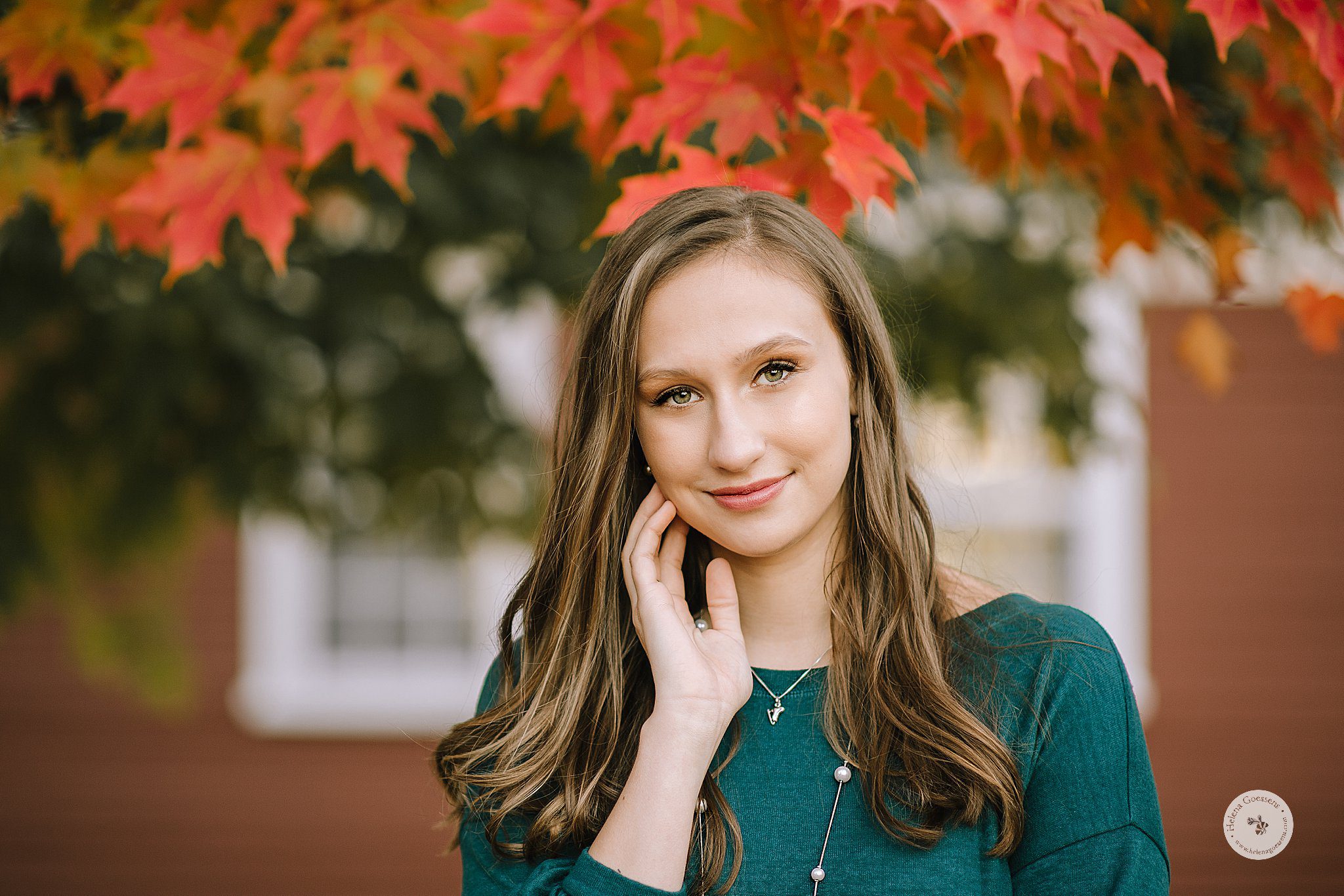 senior girl holds cheek during fall portraits at Larz Anderson Park