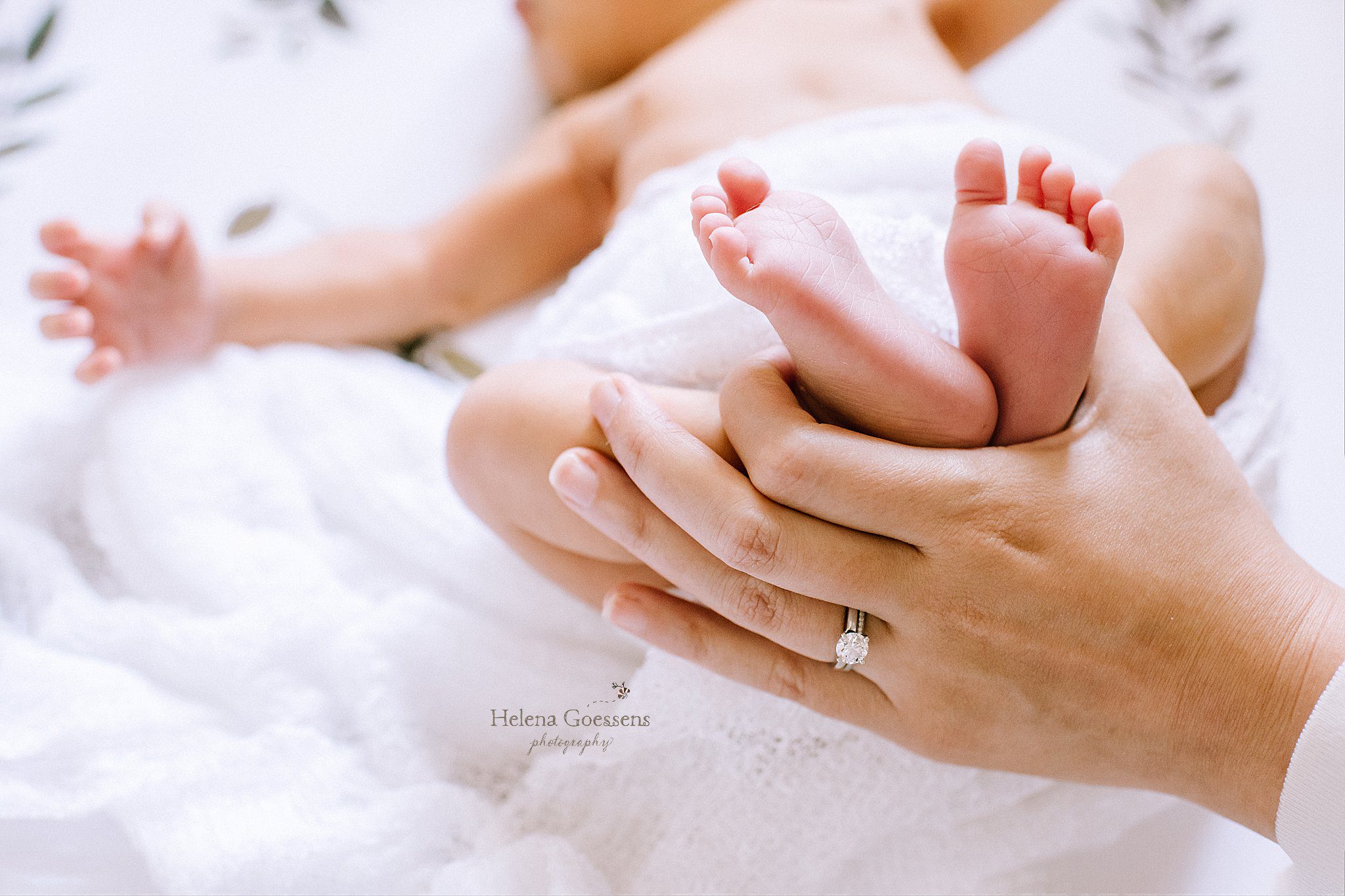 mom holds baby's feet during Chestnut Hill lifestyle newborn session