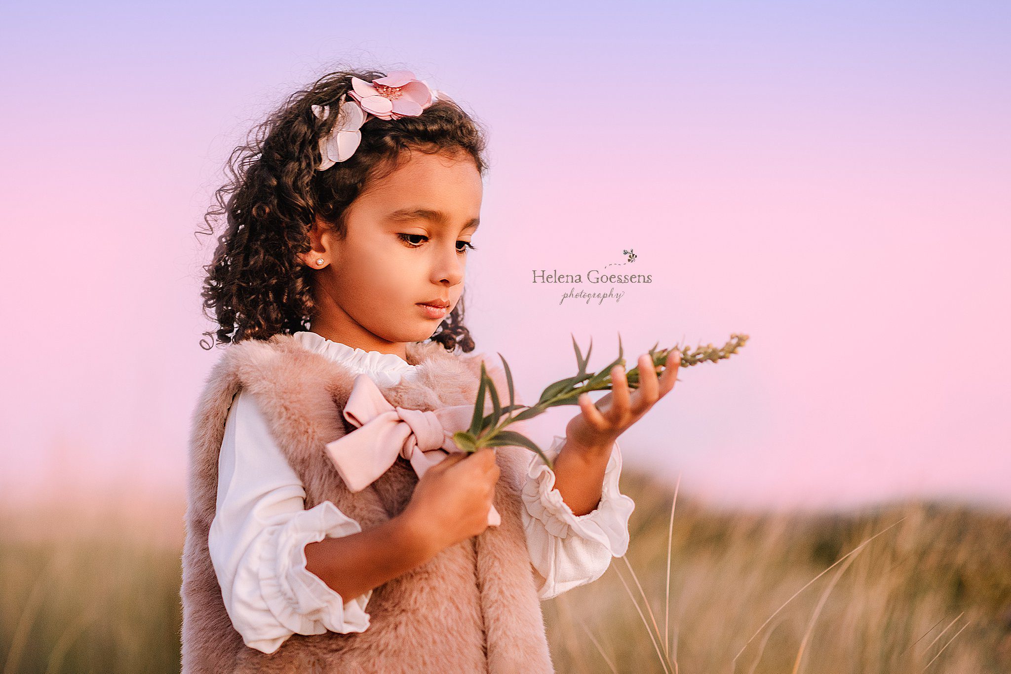 little girl plays with sand grass during Rexhame Beach family photos