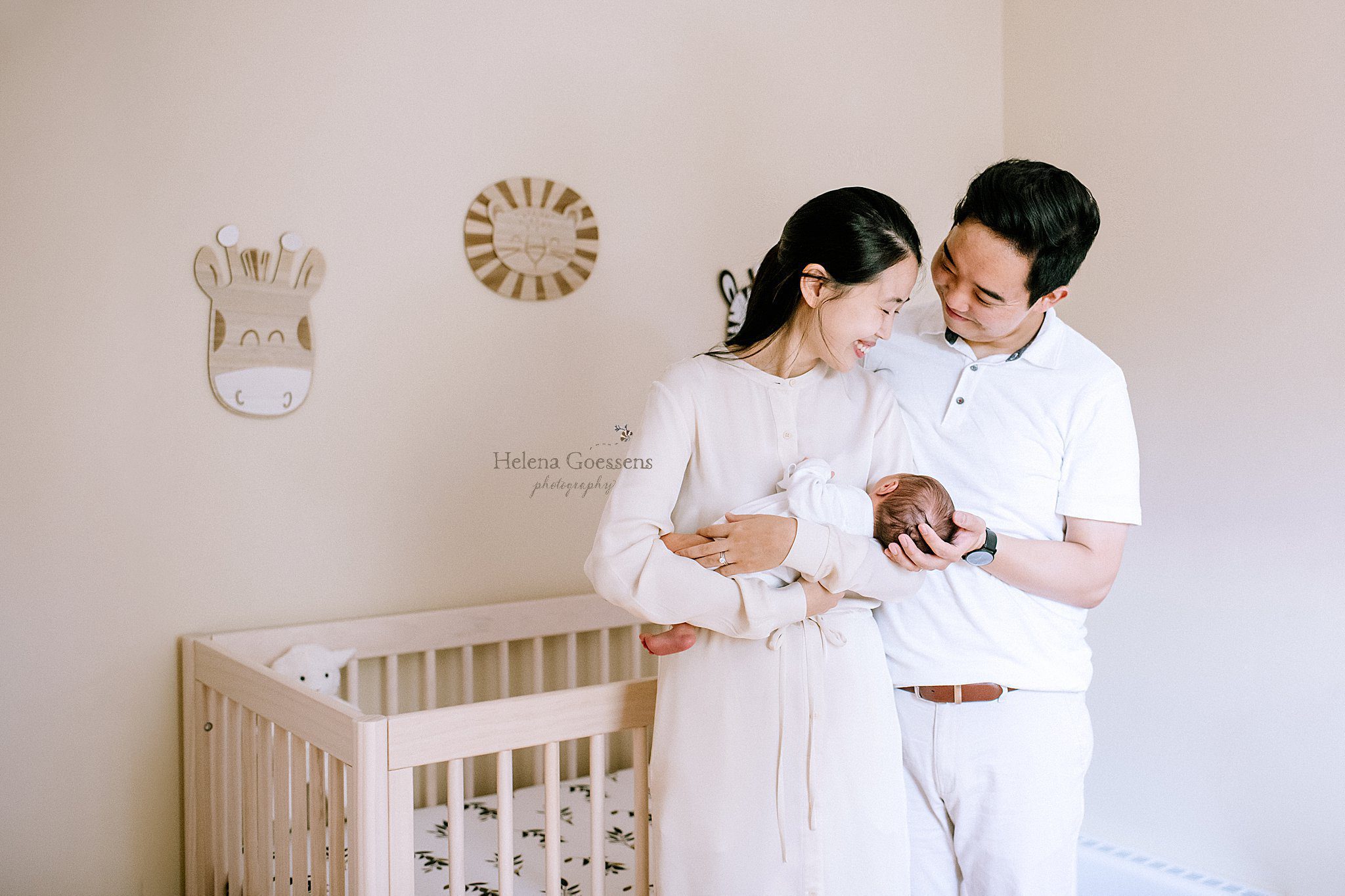 parents look at baby boy in nursery during lifestyle newborn session