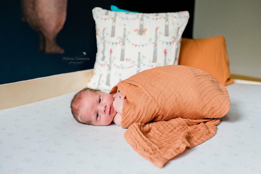 Helena Goessens Photography photographs baby boy in orange wrap on bed