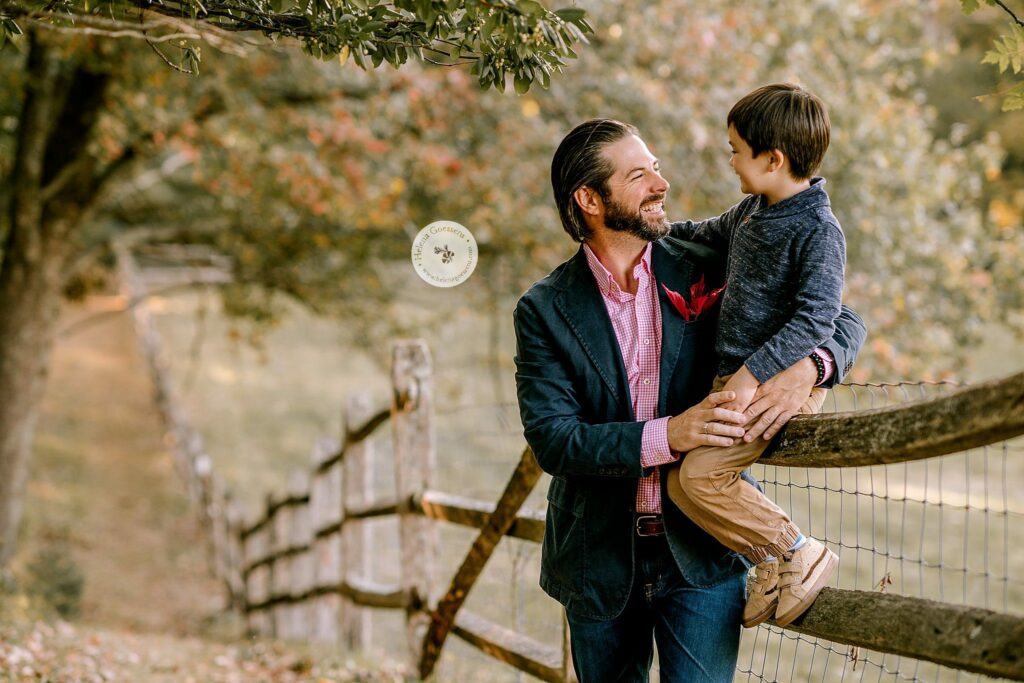 dad and son pose on fence during Bradley Estate fall family portraits with Helena Goessens Photography