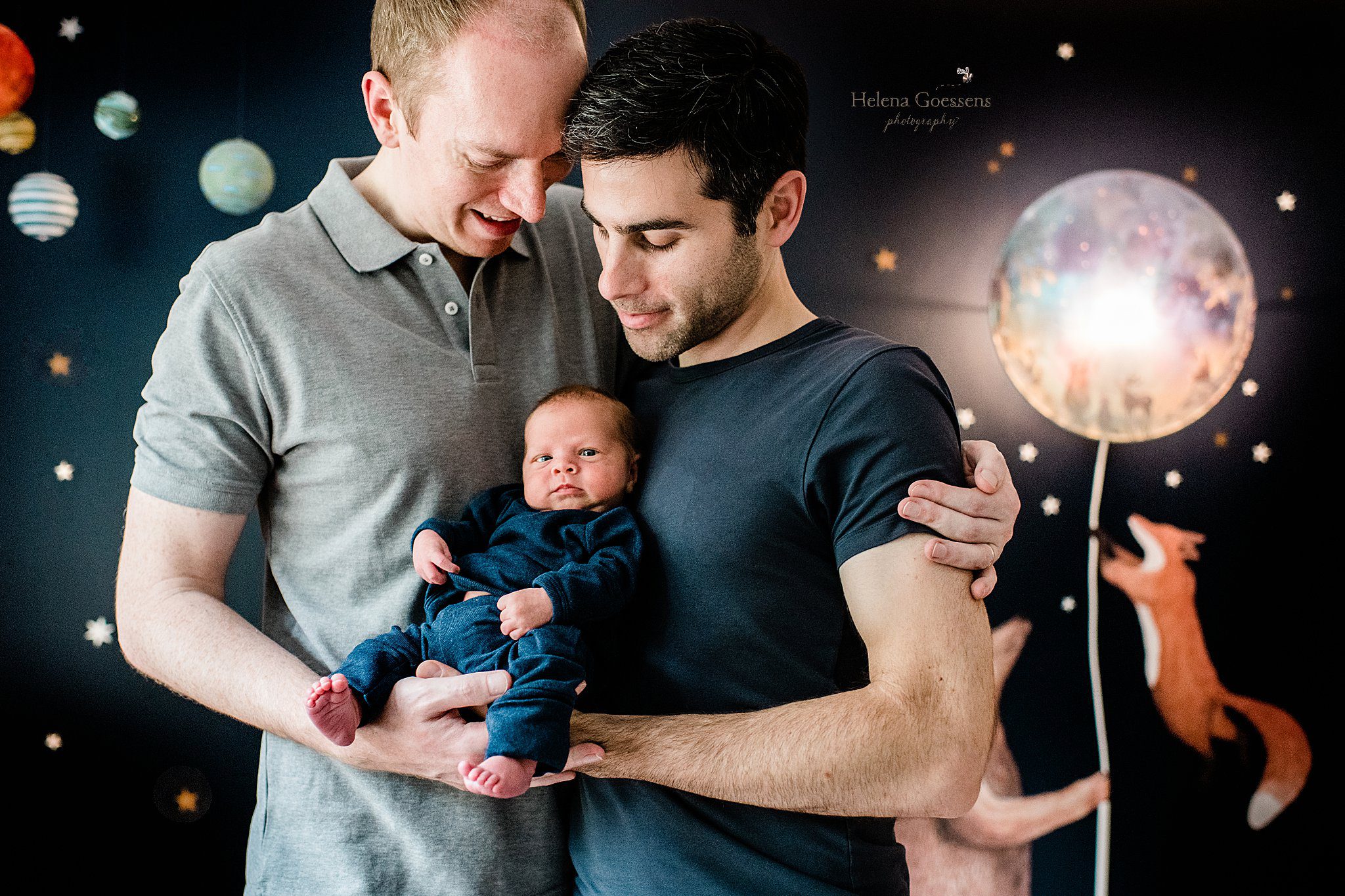 Helena Goessens Photography captures two dads holding newborn baby boy