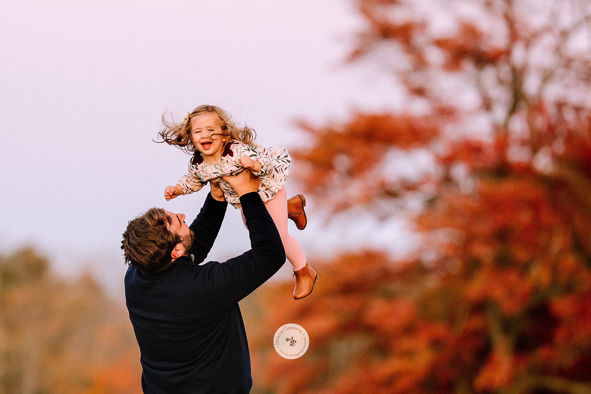 dad tosses daughter in the air during Larz Anderson Park family photos 