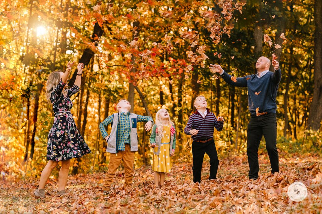 Helena Goessens Photography photographs family throwing leaves during Fall Family Portraits in Brookline MA