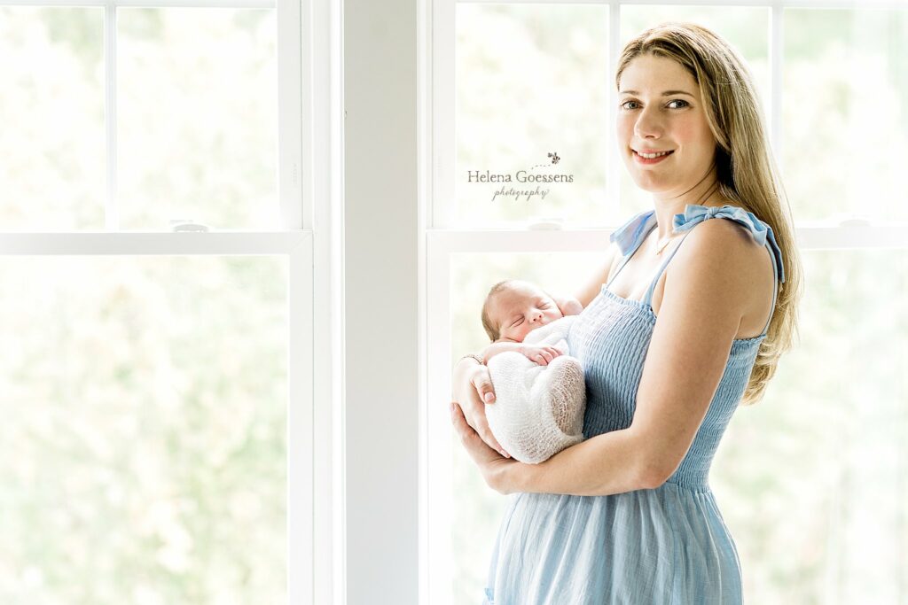 mom holds baby boy in arms during At Home Newborn Portraits