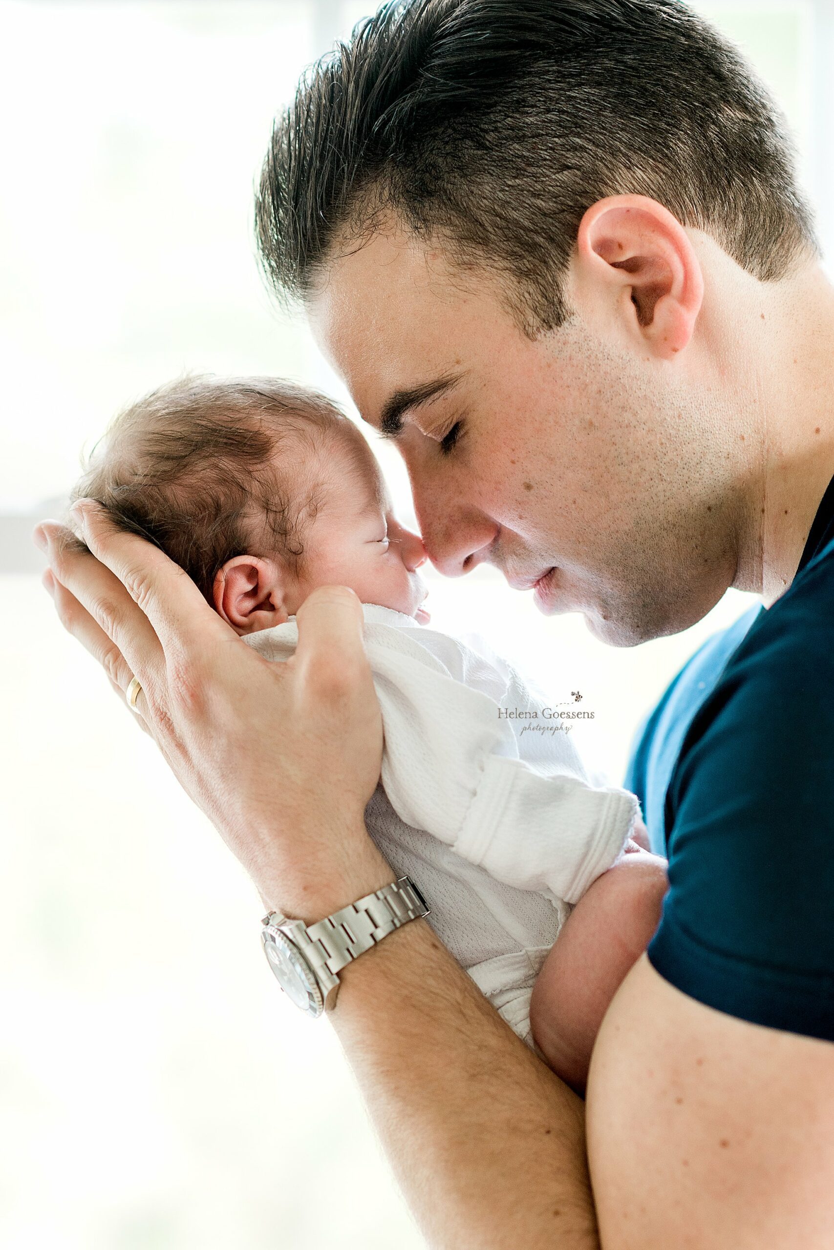 dad holds baby boy touching nose to nose during At Home Newborn Portraits