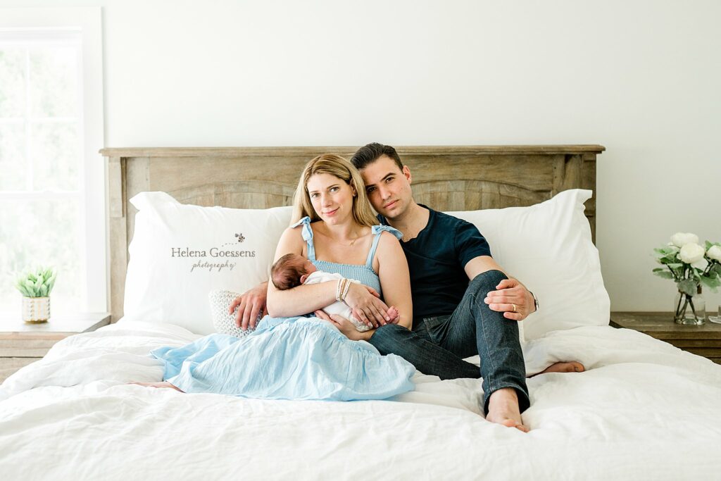 new family sits on bed with baby boy during Boston newborn photos 
