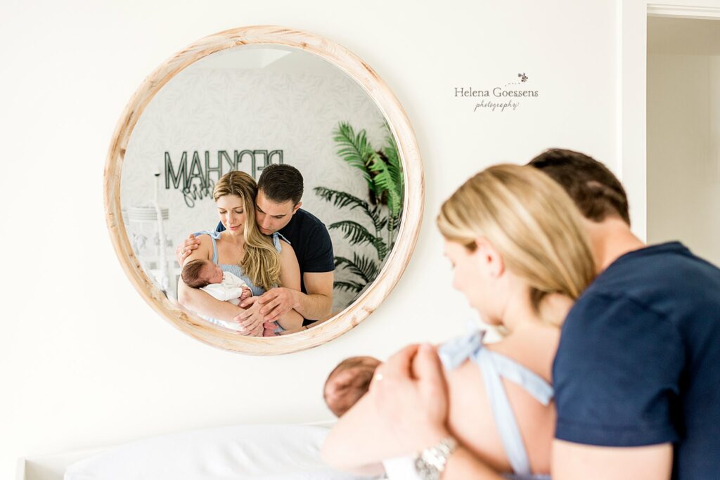 dad looks over mom's shoulder at new baby boy during MA newborn photos