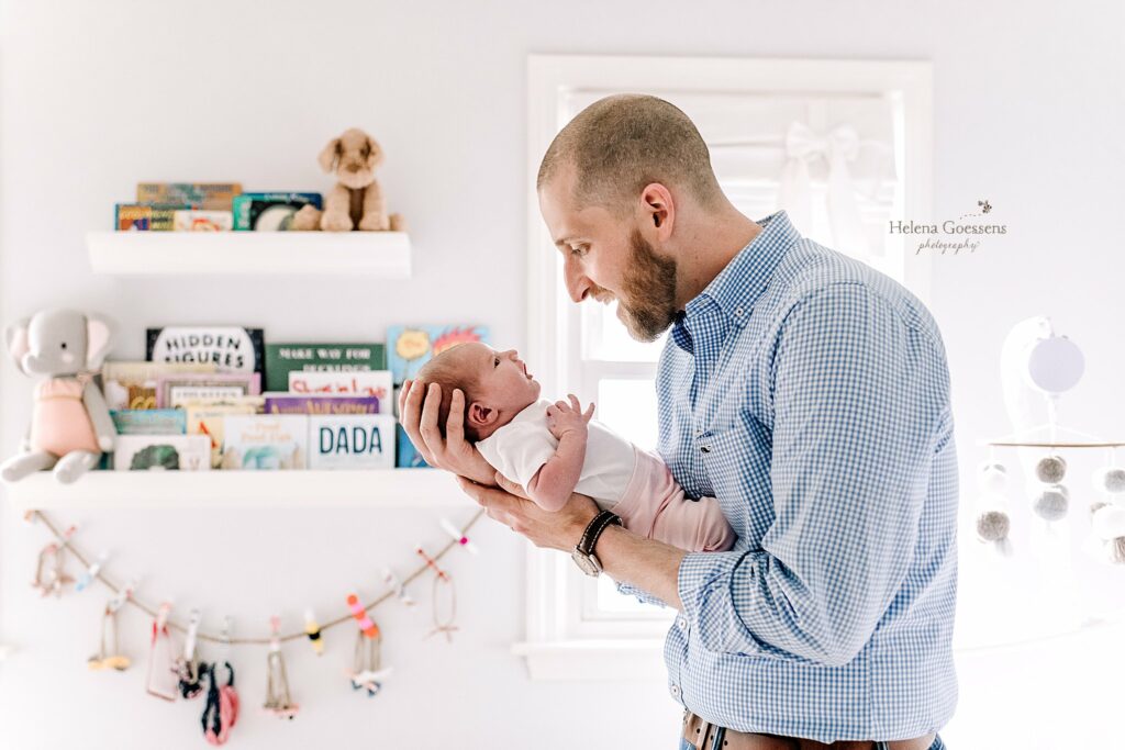 dad looks down at daughter during Lifestyle Newborn Session in Quincy MA