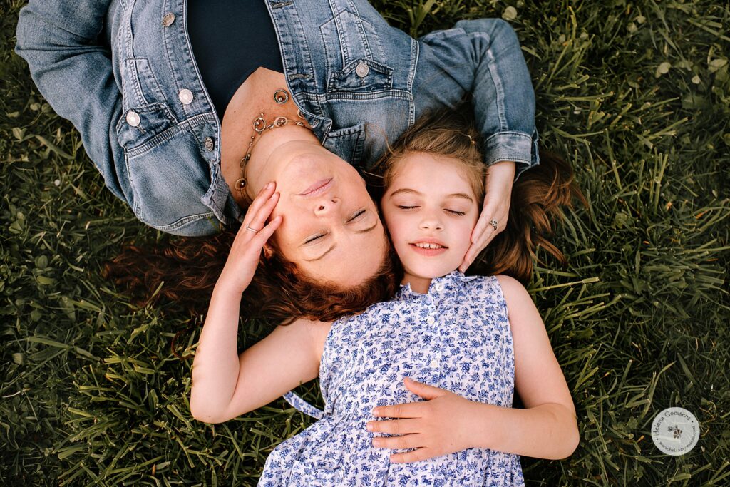 mom and daughter lay in field during Peter's Hill family photos