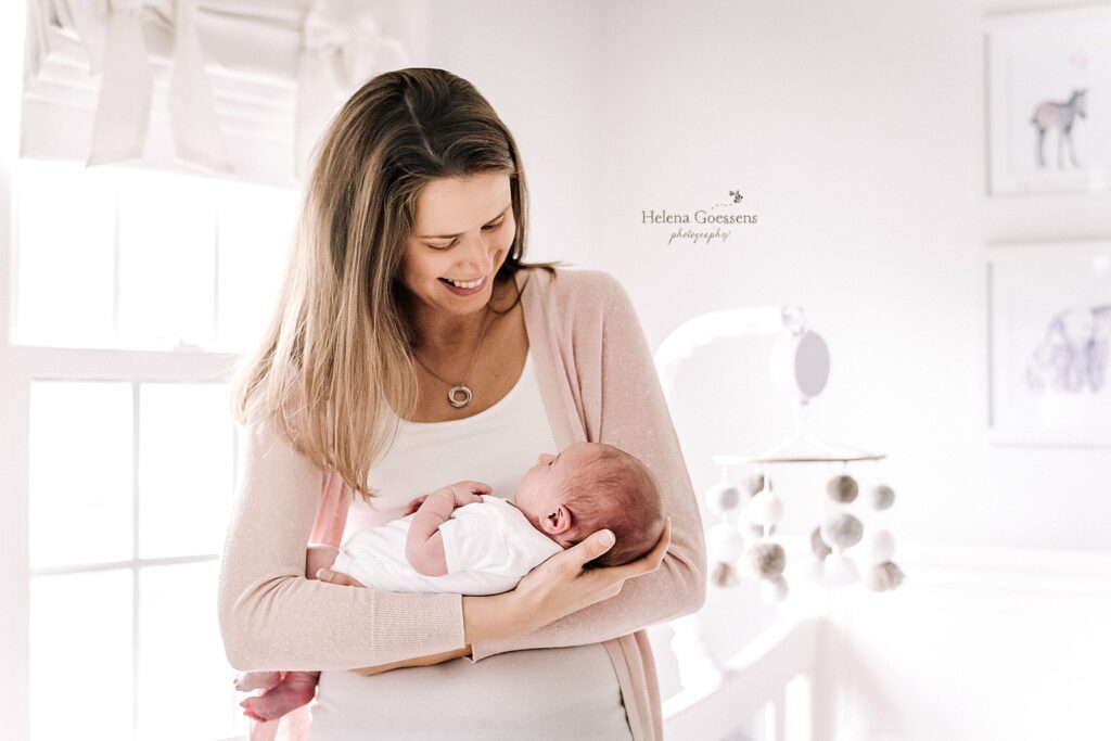mom holds baby girl in nursery during Lifestyle Newborn Session in Quincy MA